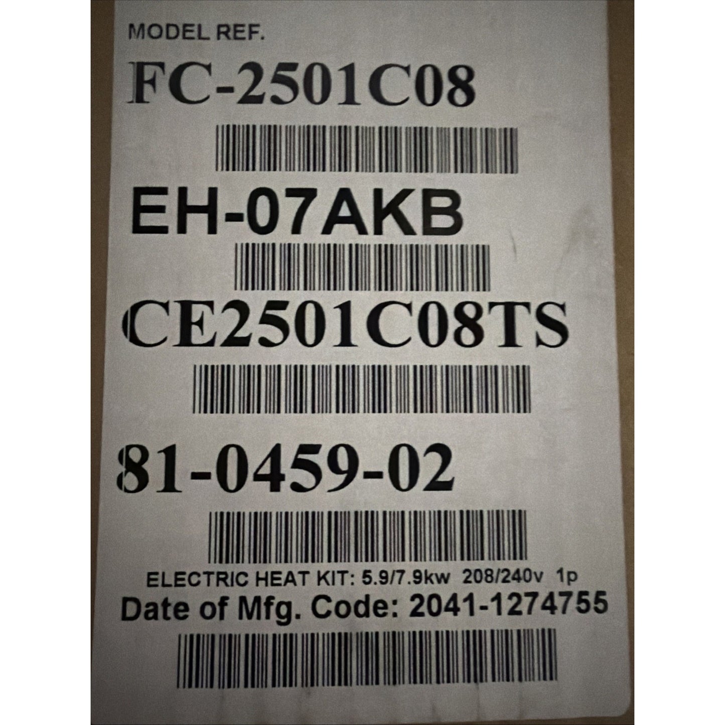 Close-up of a white label on cardboard displaying model and serial numbers, barcodes, and specifications for an electric heat kit with power ratings and manufacturing code.