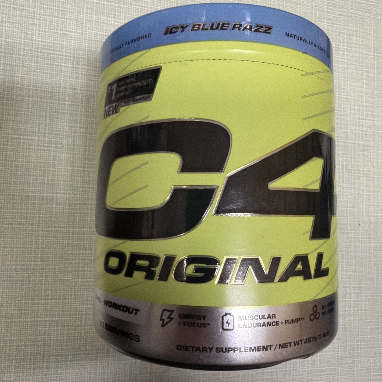 Container of C4 Original pre-workout supplement in Icy Blue Razz flavor with a yellow and blue label featuring bold black lettering and icons indicating energy, focus, and muscular endurance benefits.
