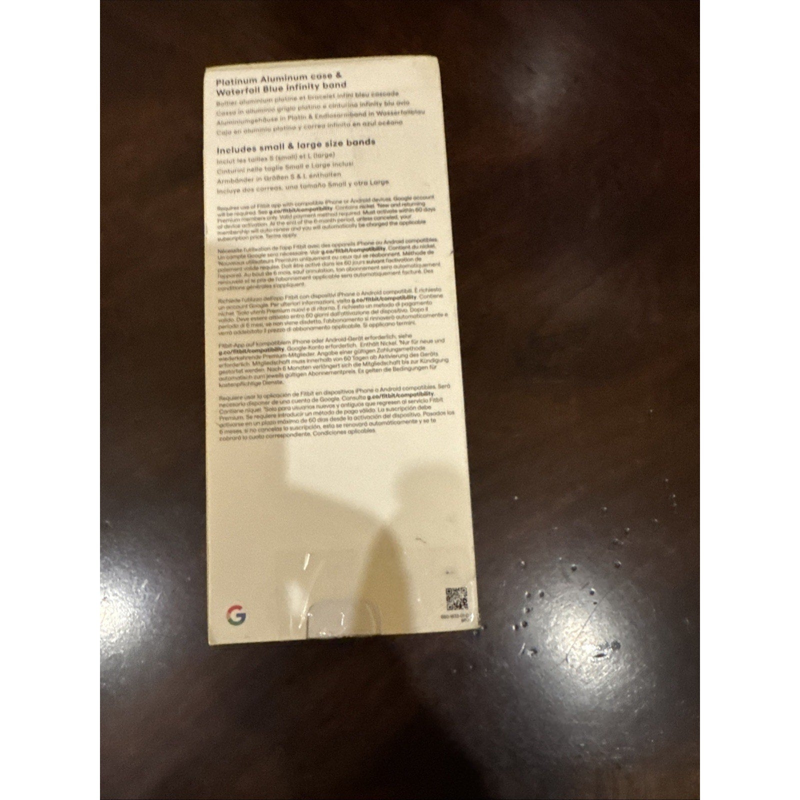 Back of Fitbit Versa 4 smartwatch box showing Platinum Aluminum Case and Waterfall Blue Infinity band details and included sizes