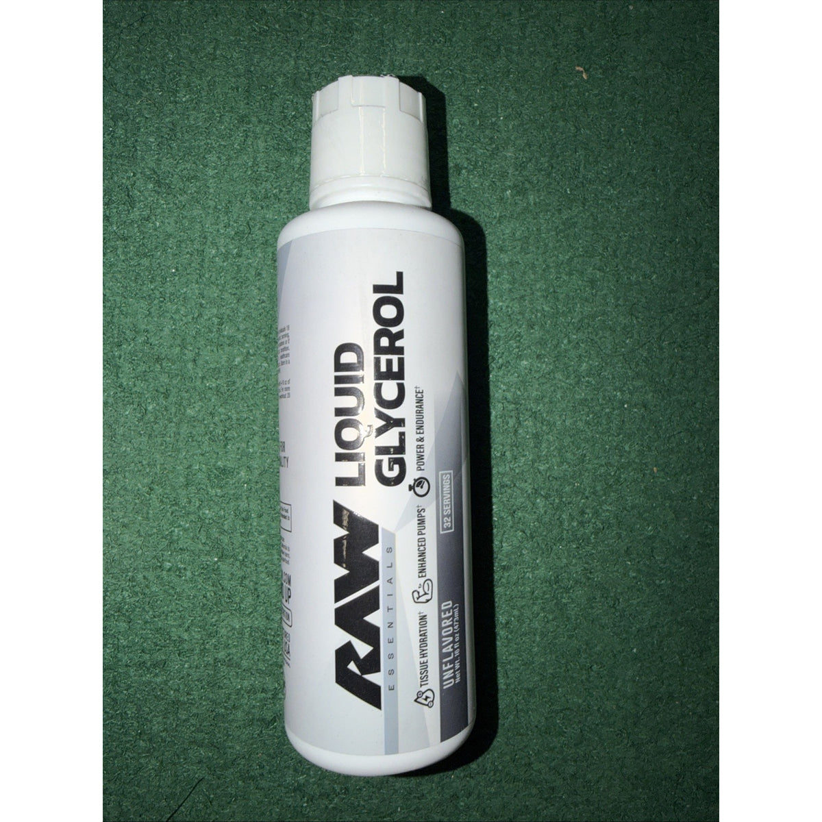 White plastic bottle labeled "Raw Liquid Glycerol" with black and gray text, placed on a green textured surface.