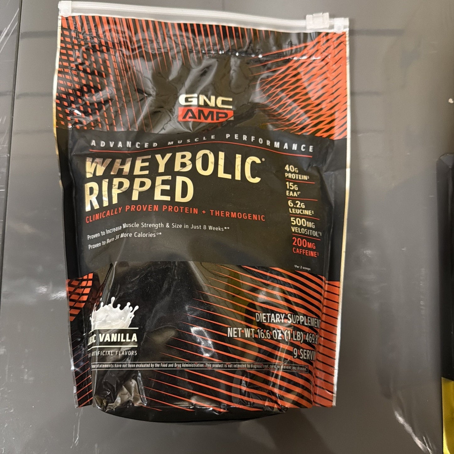 Black and orange resealable pouch of GNC AMP Wheybolic Ripped protein powder in vanilla flavor, highlighting 40g protein, 15g EAA, 6.2g leucine, 500mg Velositol, and 200mg caffeine per serving.