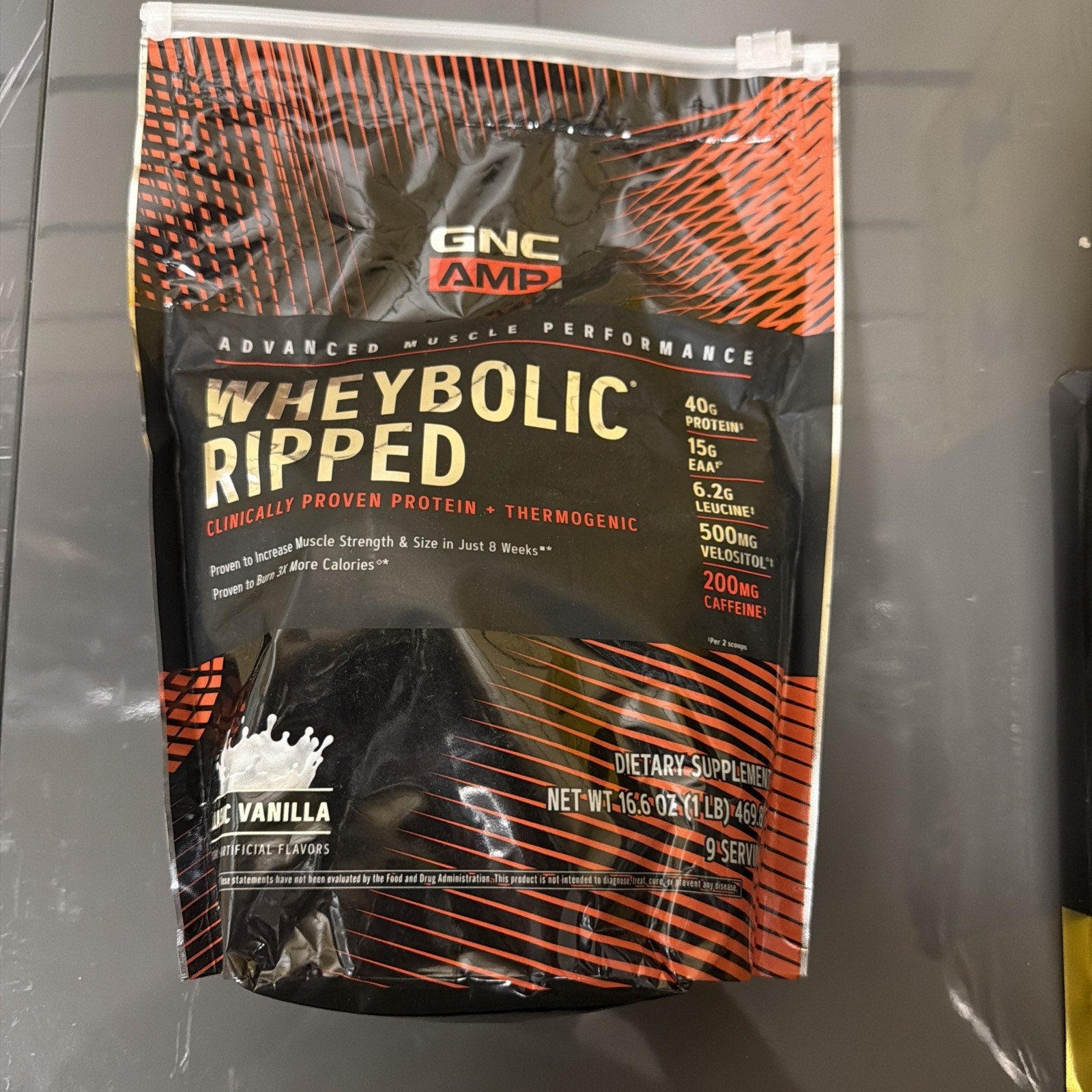 Black and orange resealable pouch of GNC AMP Wheybolic Ripped protein powder in vanilla flavor, highlighting 40g protein, 15g EAA, 6.2g leucine, 500mg Velositol, and 200mg caffeine per serving.