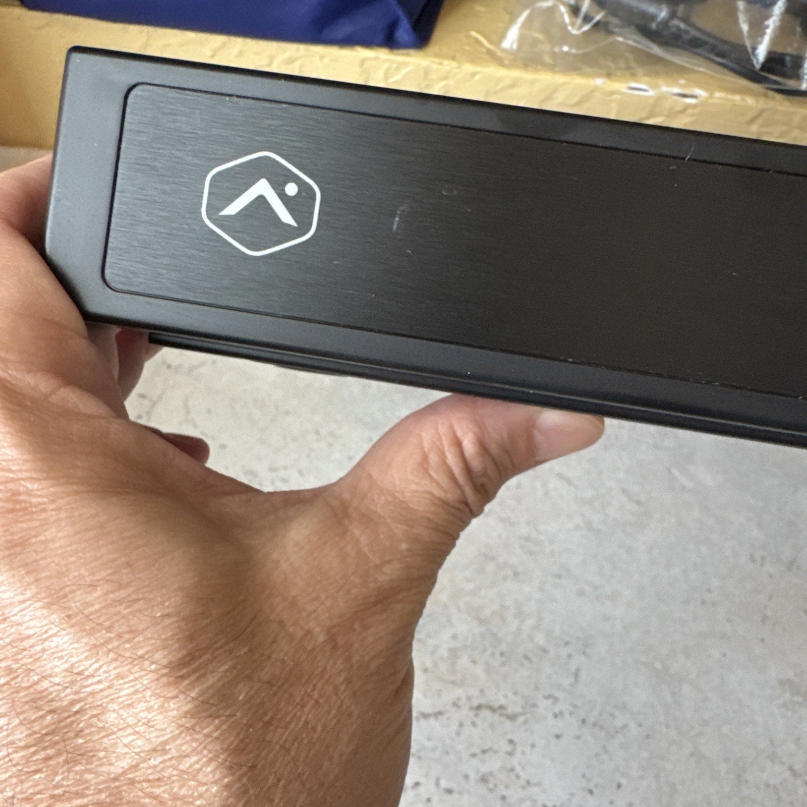 Alarm.com 8 channel commercial streaming video recorder showing front panel with Alarm.com logo and hand holding device