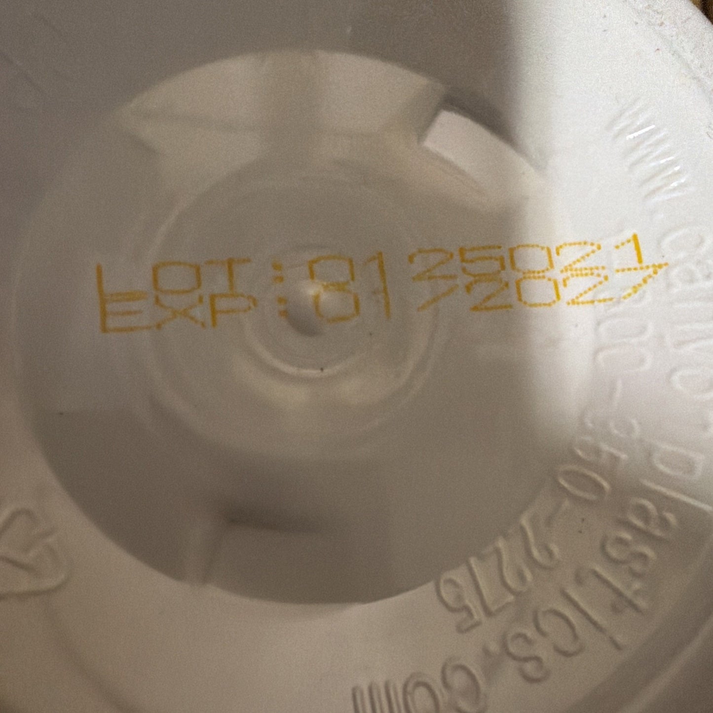 Close-up of yellow printed lot number "8125021" and expiration date "8/2024" on an off-white plastic surface with molded text and markings around the edge.