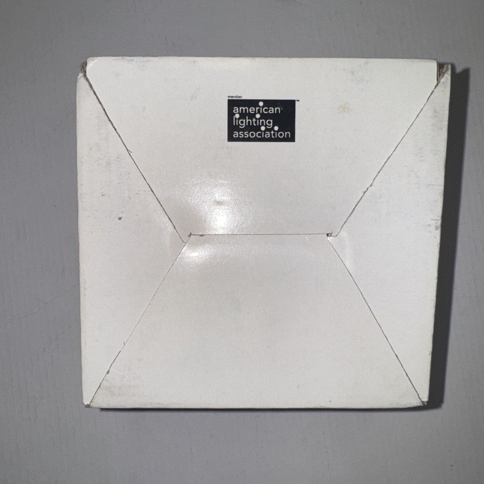 White square box packaging with American Lighting Association logo on gray background viewed from top angle