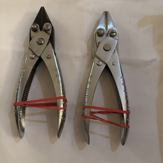 Pair of aviation snips sheet metal shears with left cut and straight cut blades held by red bands on white background