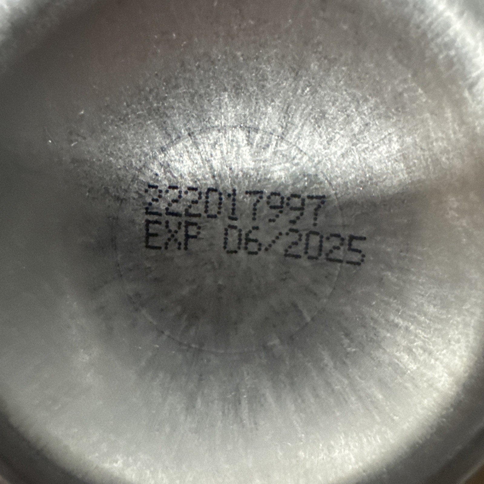 Close-up of expiration date code printed on the bottom of a Banana Boat Sport Ultra Sunscreen SPF 50 can