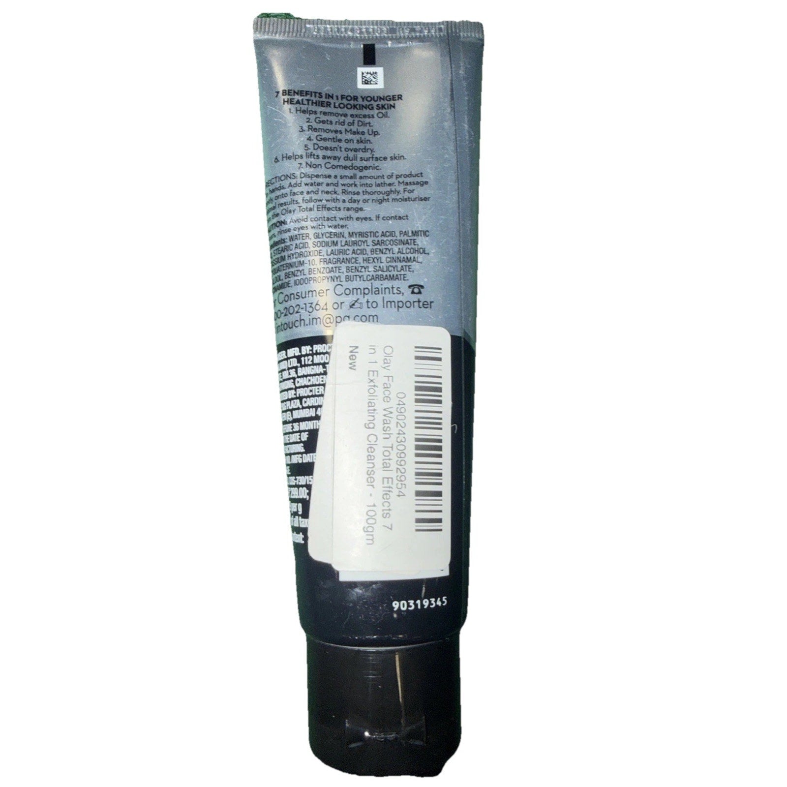 Back view of a black and silver cosmetic tube with a barcode sticker on the lower half, showing printed product information, usage instructions, and safety details.