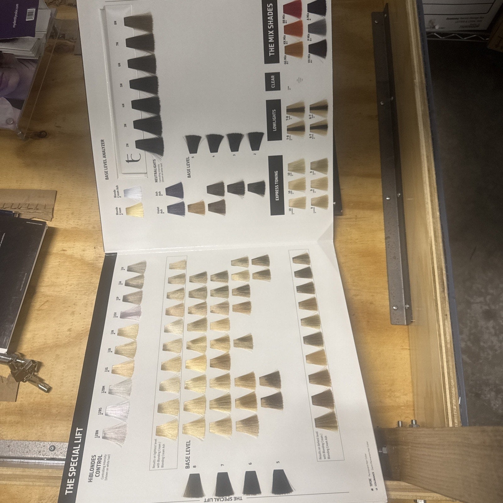 Goldwell Color Catalog open on wooden table showing hair color swatches for special lift and high shades categories