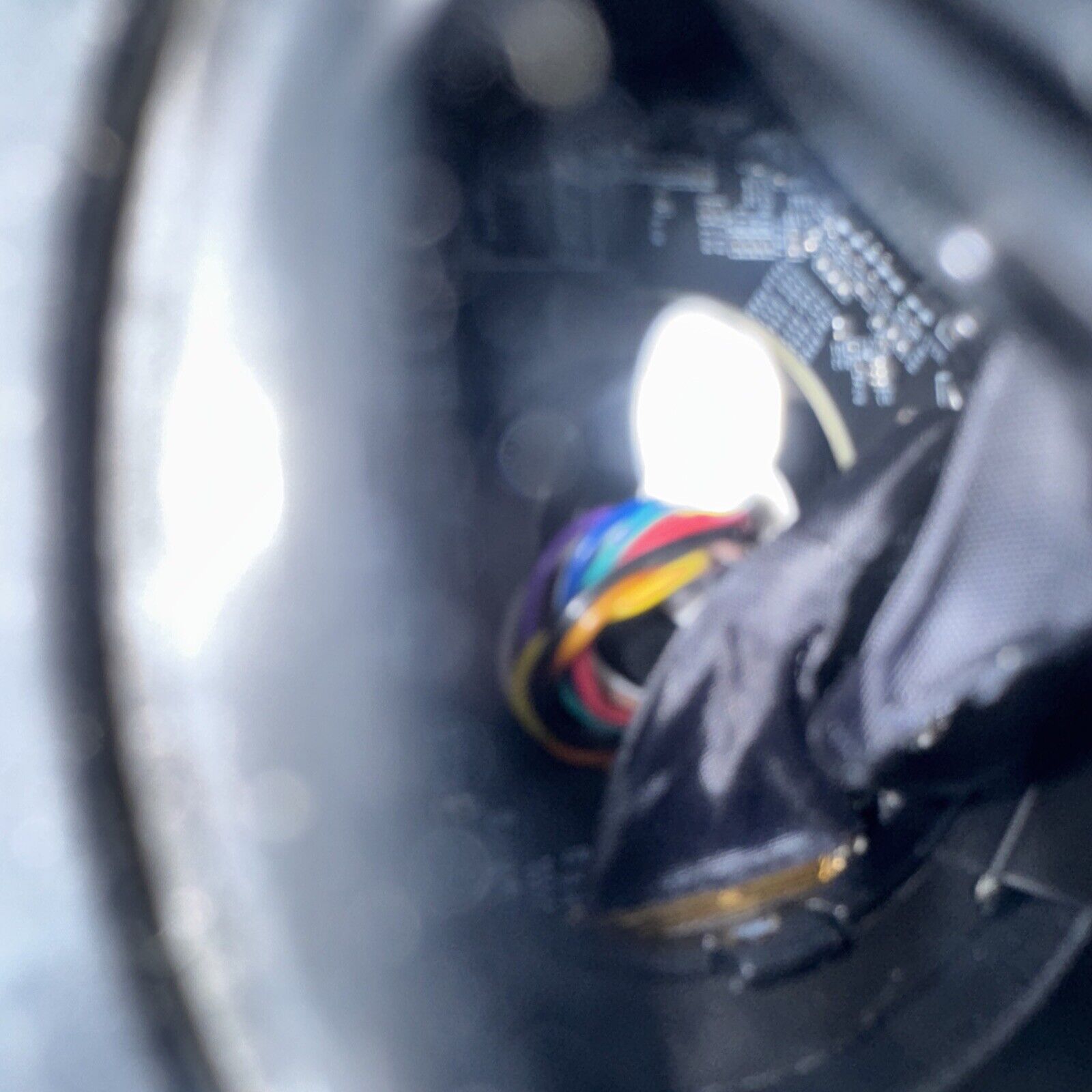 Close-up of multicolored wires inside the base of an Alarm.com surveillance camera with electronic components visible
