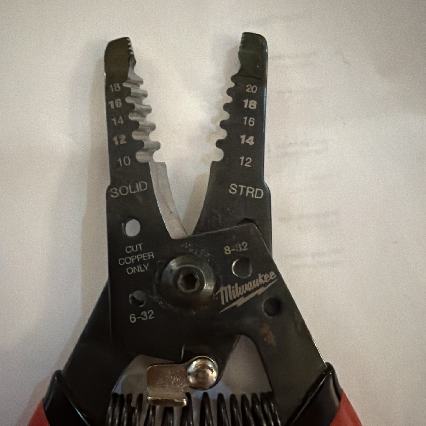 Milwaukee Automatic Wire Stripper showing jaws with wire gauge sizes 10 to 20 AWG and solid and stranded markings