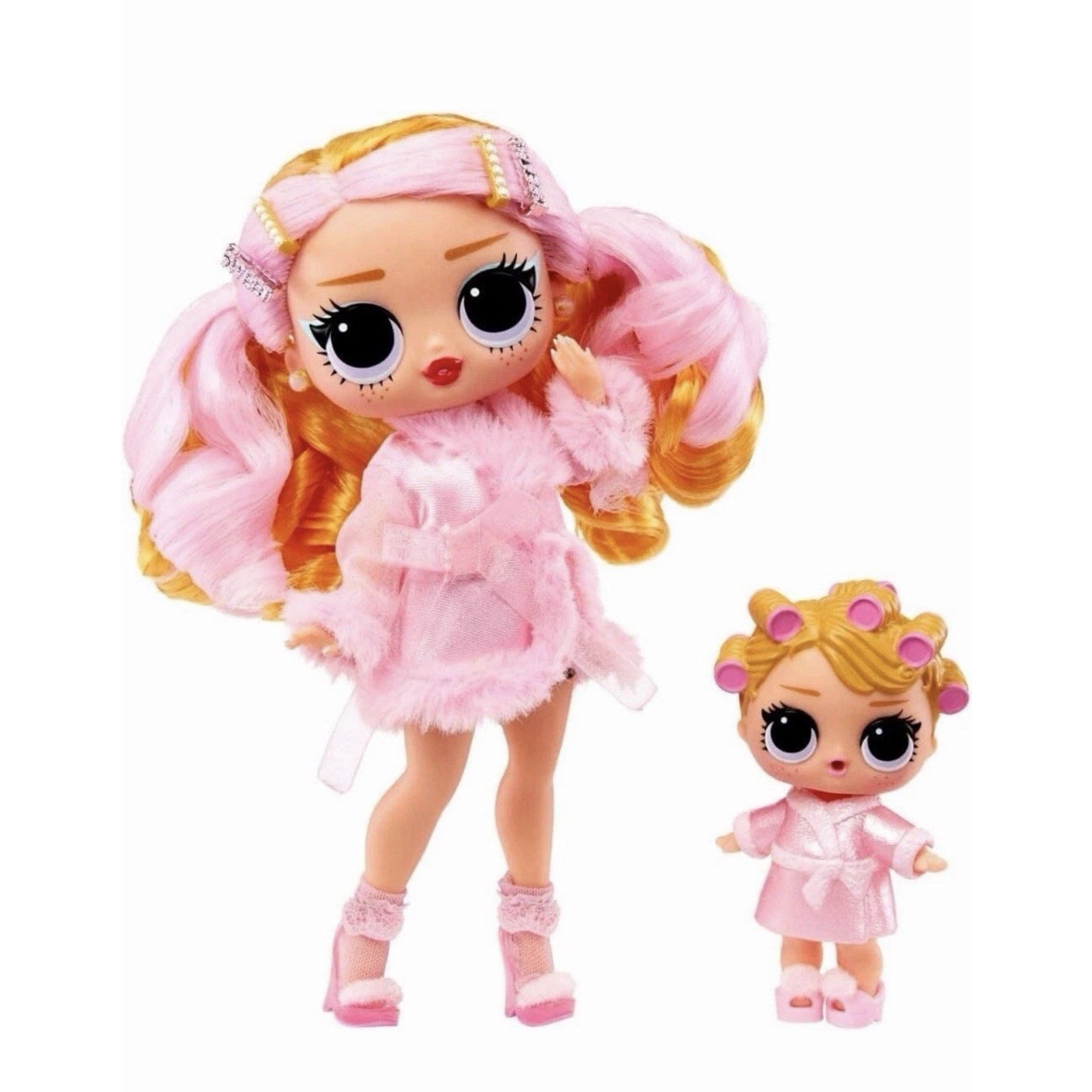 Two dolls dressed in pink robes, one larger with long pink and blonde hair styled with hair clips and the smaller wearing pink hair rollers, both with large expressive eyes and slippers.