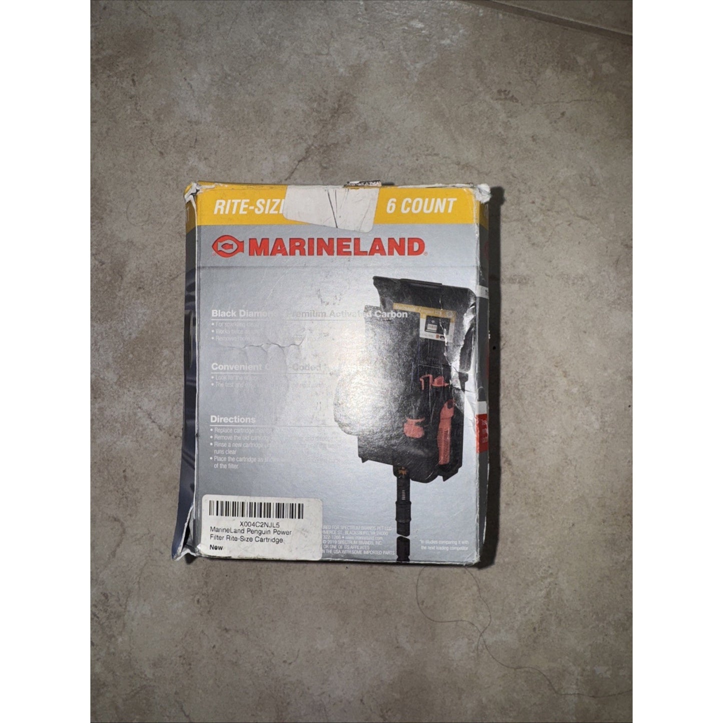 Worn and slightly damaged packaging box for Marineland Rite-Size 6-count filter media cartridges, featuring product image and branding on a gray and yellow background.