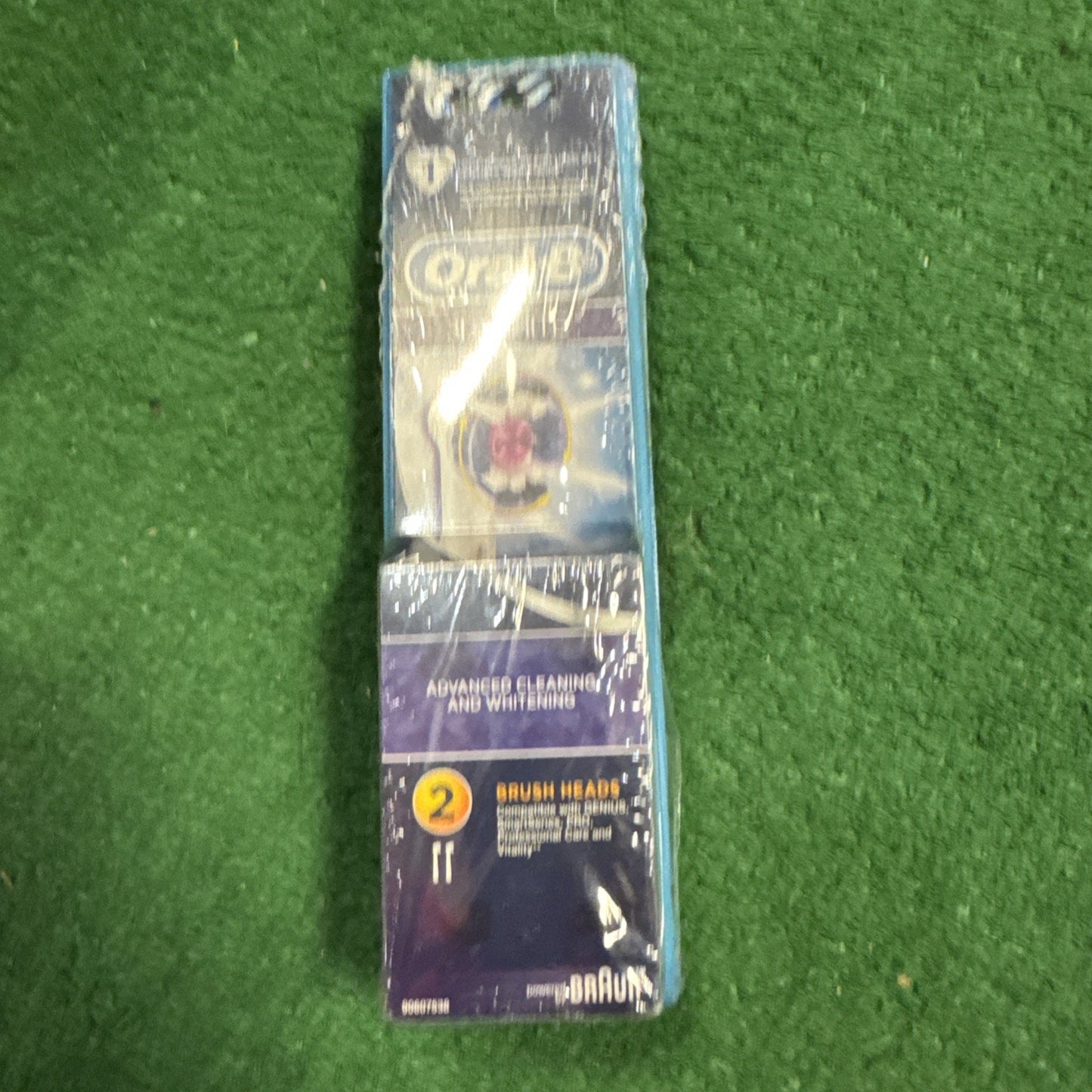 Oral B 3D White replacement electric toothbrush heads pack showing two brush heads in sealed packaging on green background