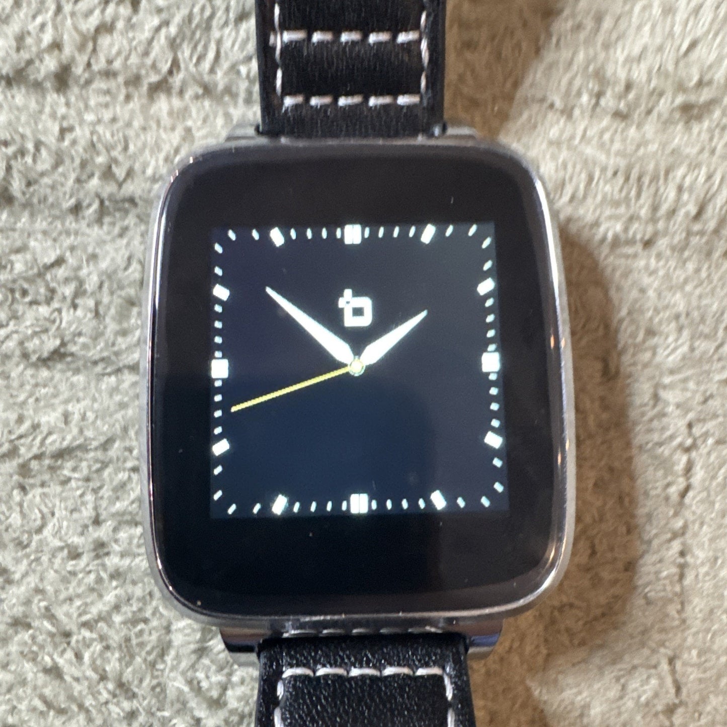 Bit Smart Watch Model S1 with black leather band showing analog clock face on square touchscreen display