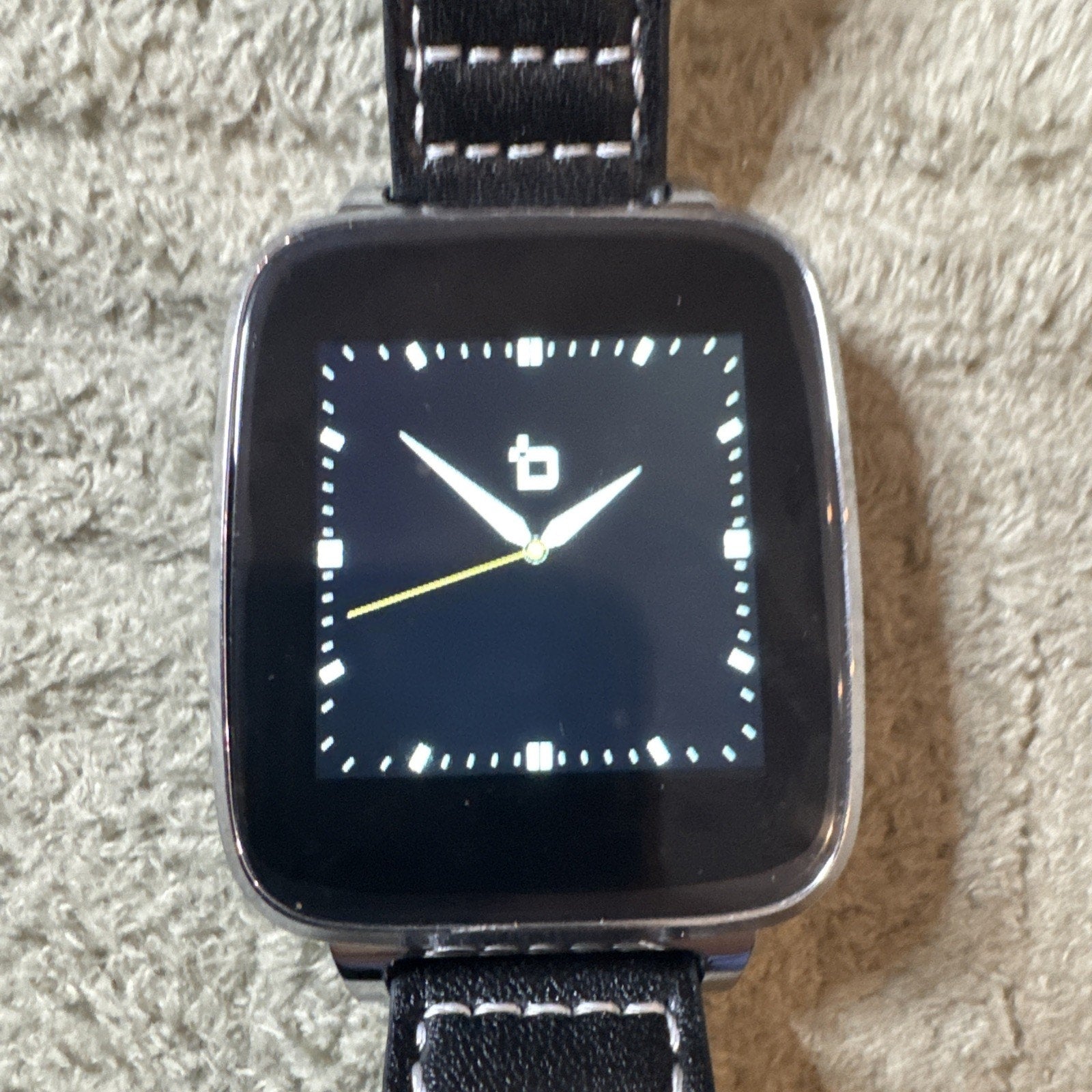 Bit Smart Watch Model S1 with black leather band showing analog clock face on square touchscreen display