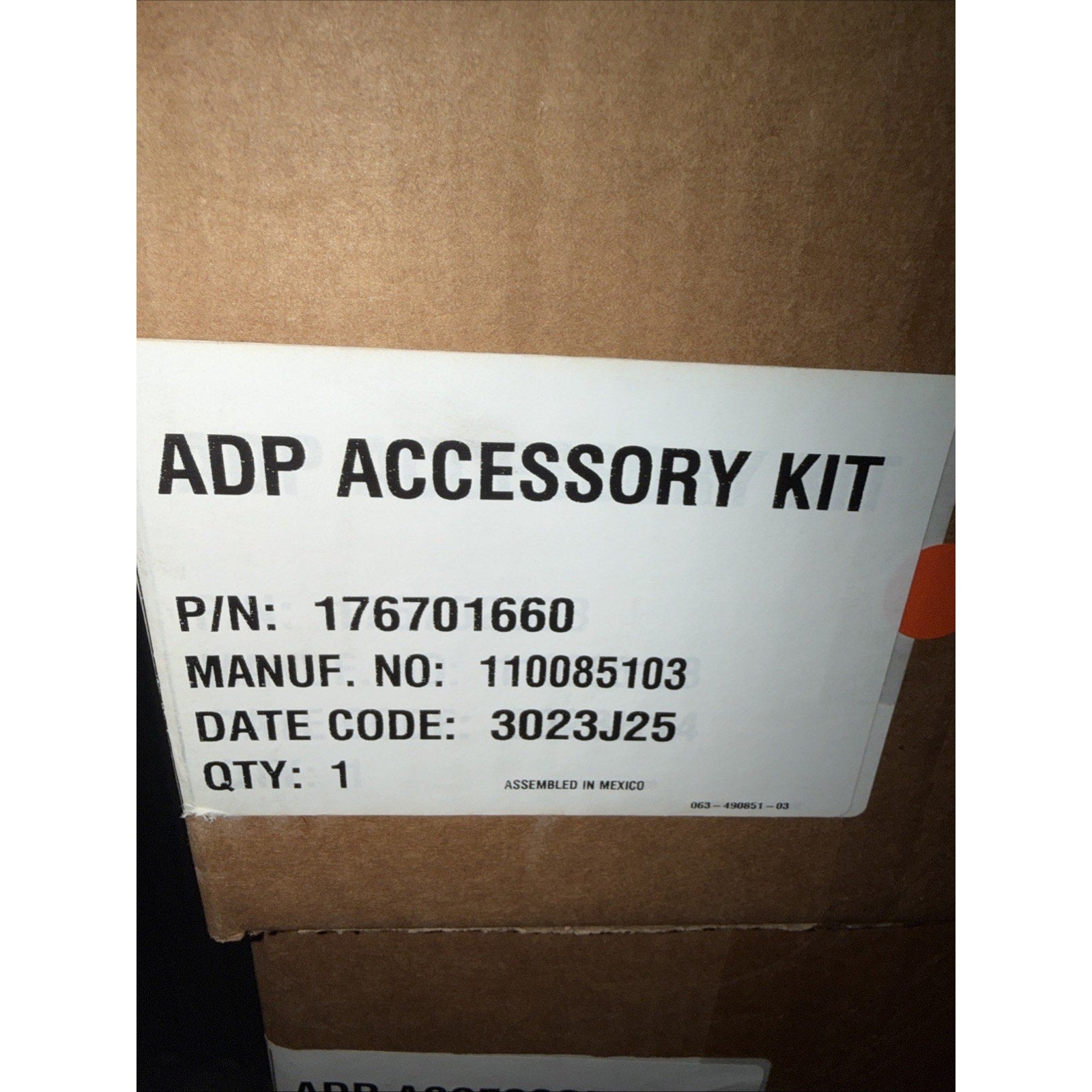 White label with black text on a brown cardboard box showing "ADP ACCESSORY KIT," part number, manufacturing code, date code, quantity, and "Assembled in Mexico" note.