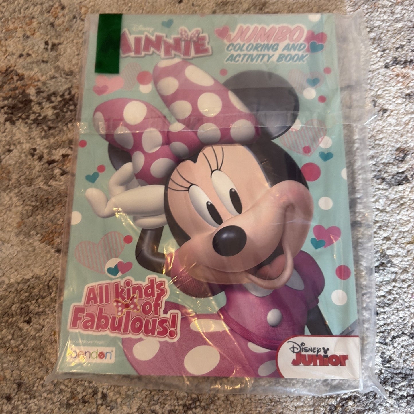 Shrink-wrapped Disney Junior Minnie Mouse jumbo coloring and activity book featuring a large smiling Minnie with a pink and white polka dot bow and the phrase "All kinds of Fabulous!" on a light blue background with hearts.