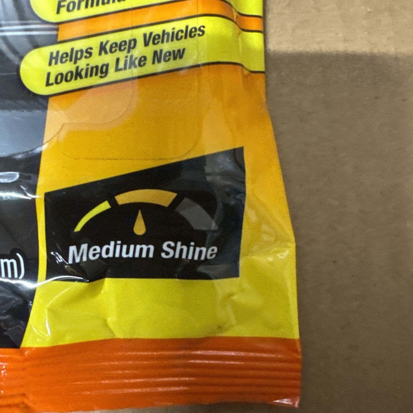 Close-up of Armor All Vehicle Protectant packaging showing medium shine level indicator on yellow and orange bag