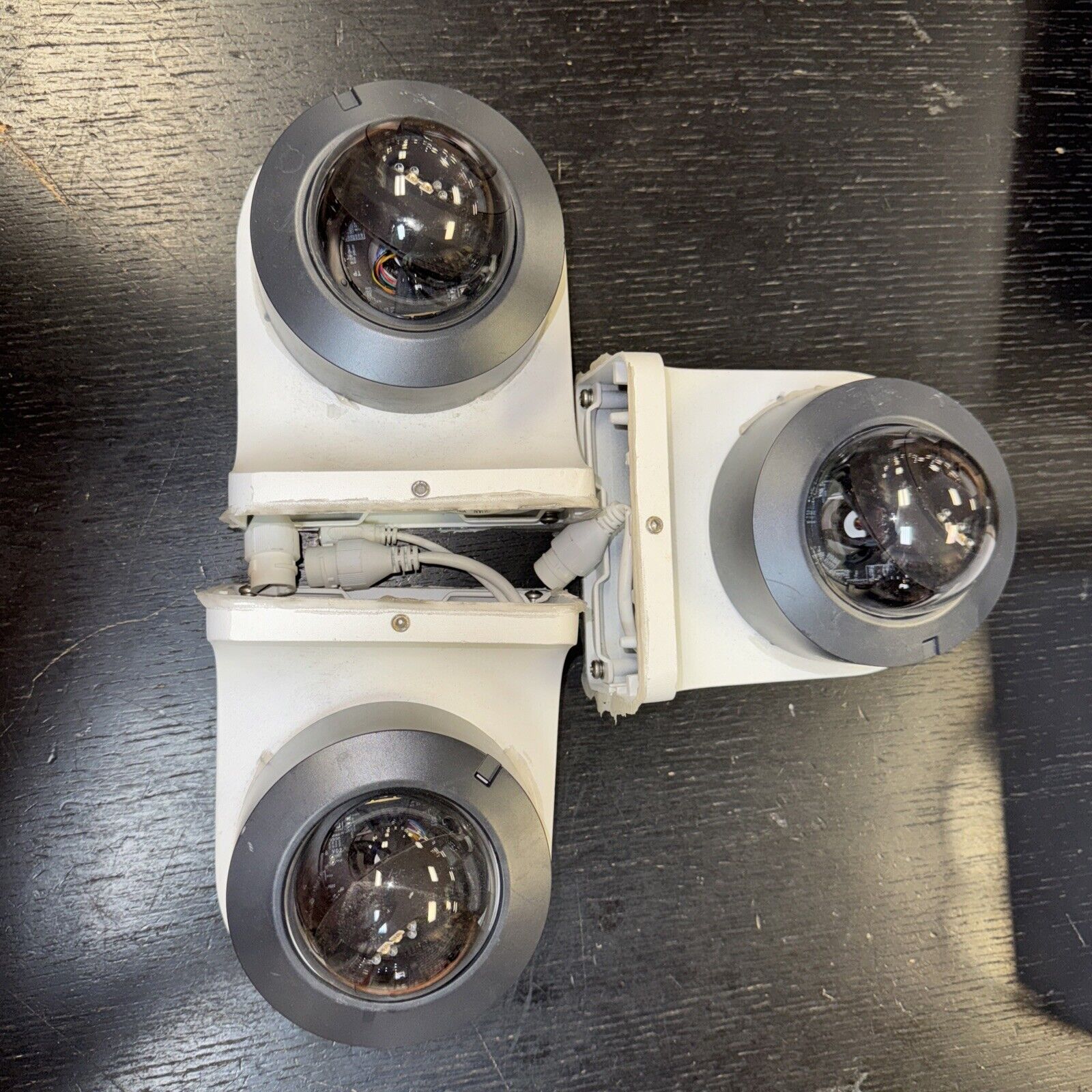 Lot of three Alarm.com dome security cameras with infrared lenses and mounting bases shown on dark surface