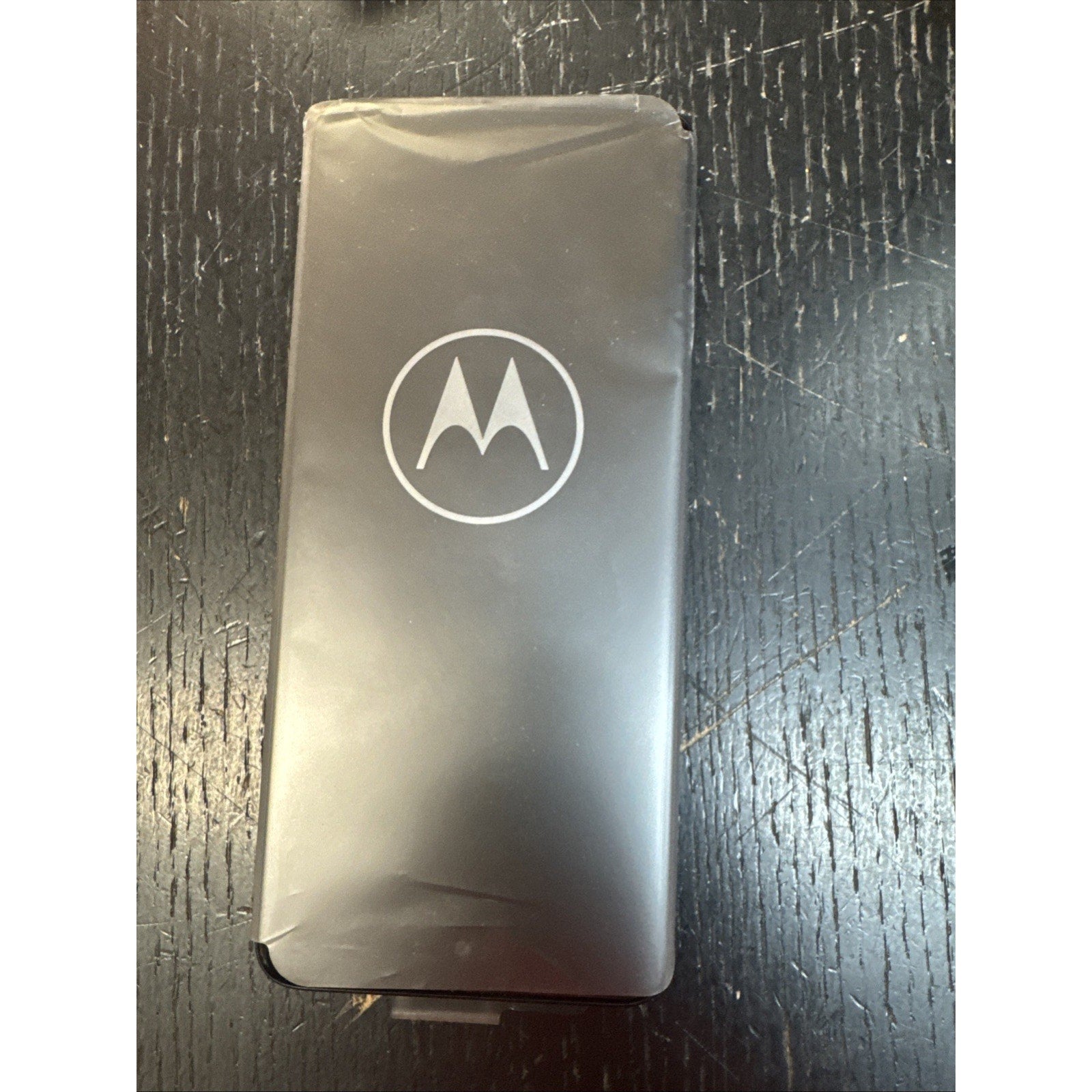 Open Box Motorola Moto Edge Plus 2022 XT2201 smartphone in Cosmos Blue with protective film on screen lying on textured surface