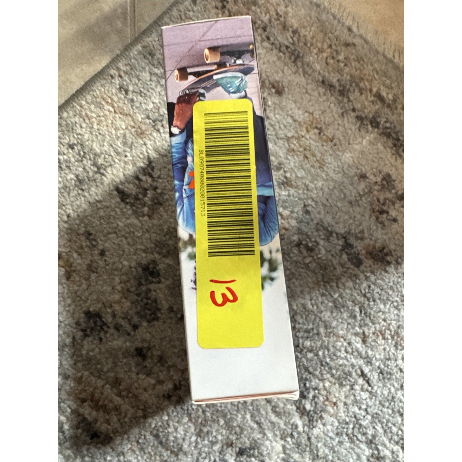 Side view of JBL by Harman Tune Beam Earbuds black box with yellow barcode sticker and handwritten number 13