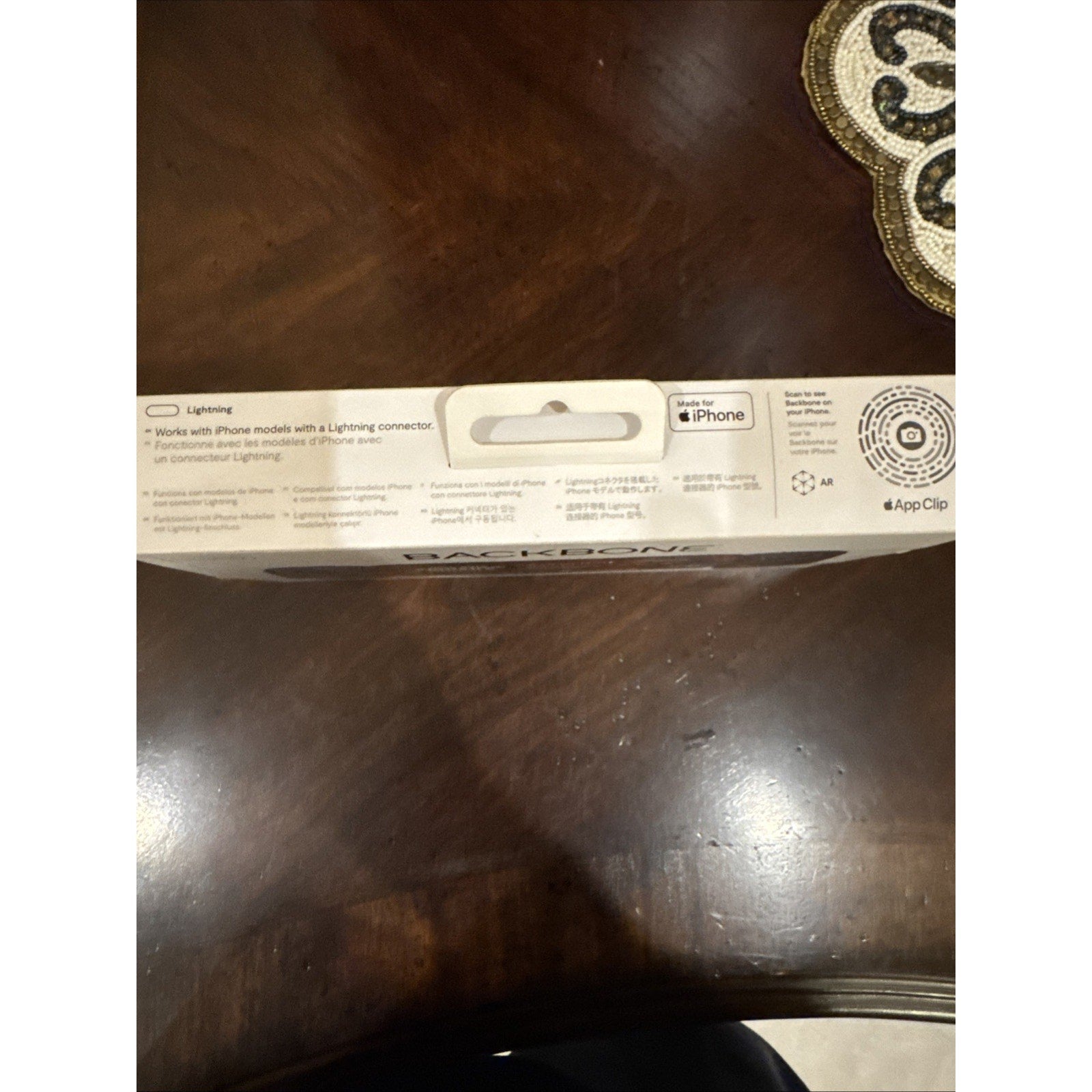 Backbone One Mobile Gaming Controller for iPhone packaging showing Lightning connector compatibility and Apple App Clip details