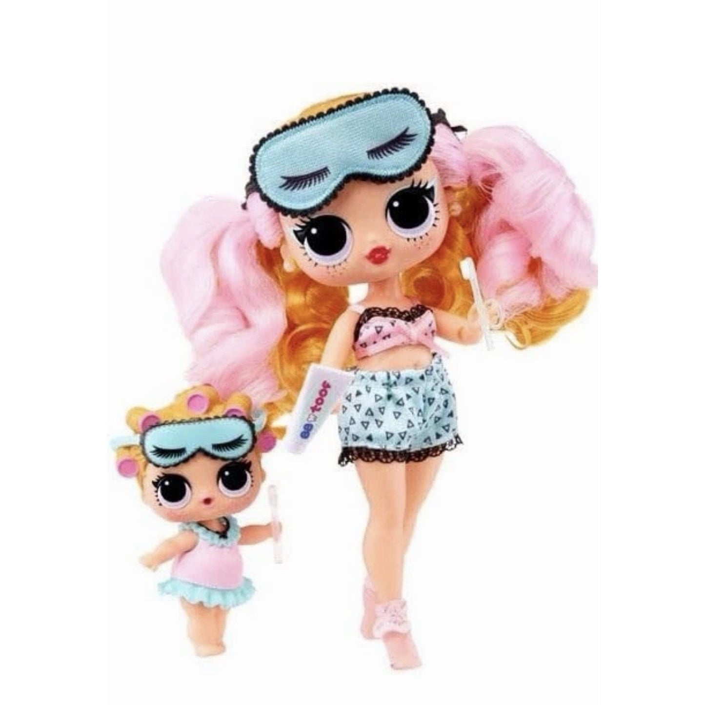 Two dolls with large eyes dressed in sleepwear; the larger doll wears a pink top and blue shorts with a blue sleep mask on her head, while the smaller doll wears a pink and blue outfit with matching eye mask and hair rollers.