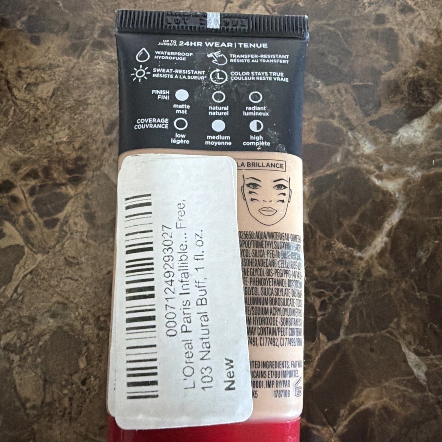 Back of a L'Oréal Paris foundation tube showing product details including waterproof and sweat-resistant features, coverage options, and a label with shade 103 Natural Buff and volume 1 fl. oz.