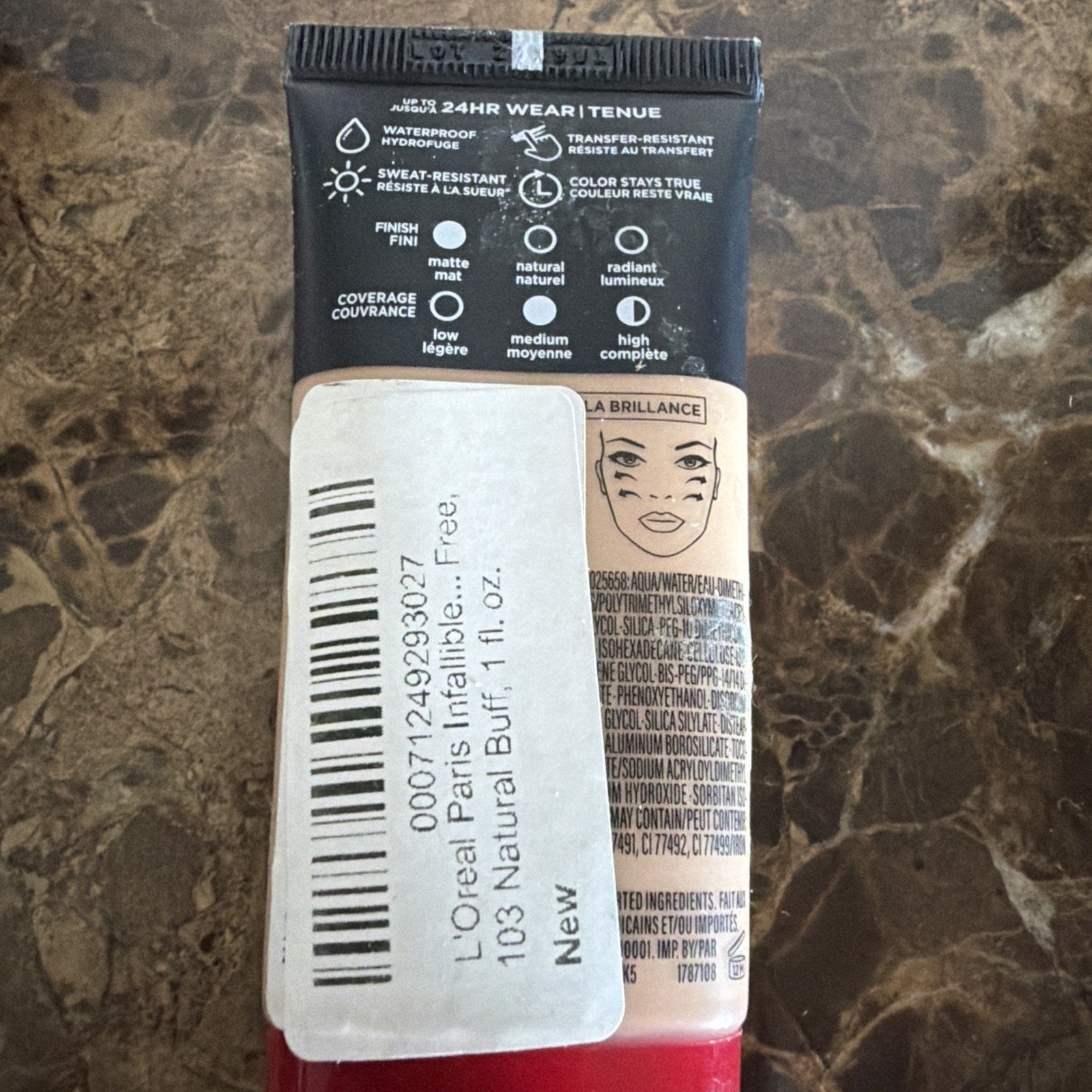 Back of a L'Oréal Paris foundation tube showing product details including waterproof and sweat-resistant features, coverage options, and a label with shade 103 Natural Buff and volume 1 fl. oz.
