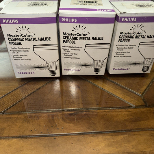 Three Philips MasterColor Ceramic Metal Halide PAR30L 35 watt flood light bulb boxes arranged on wooden floor