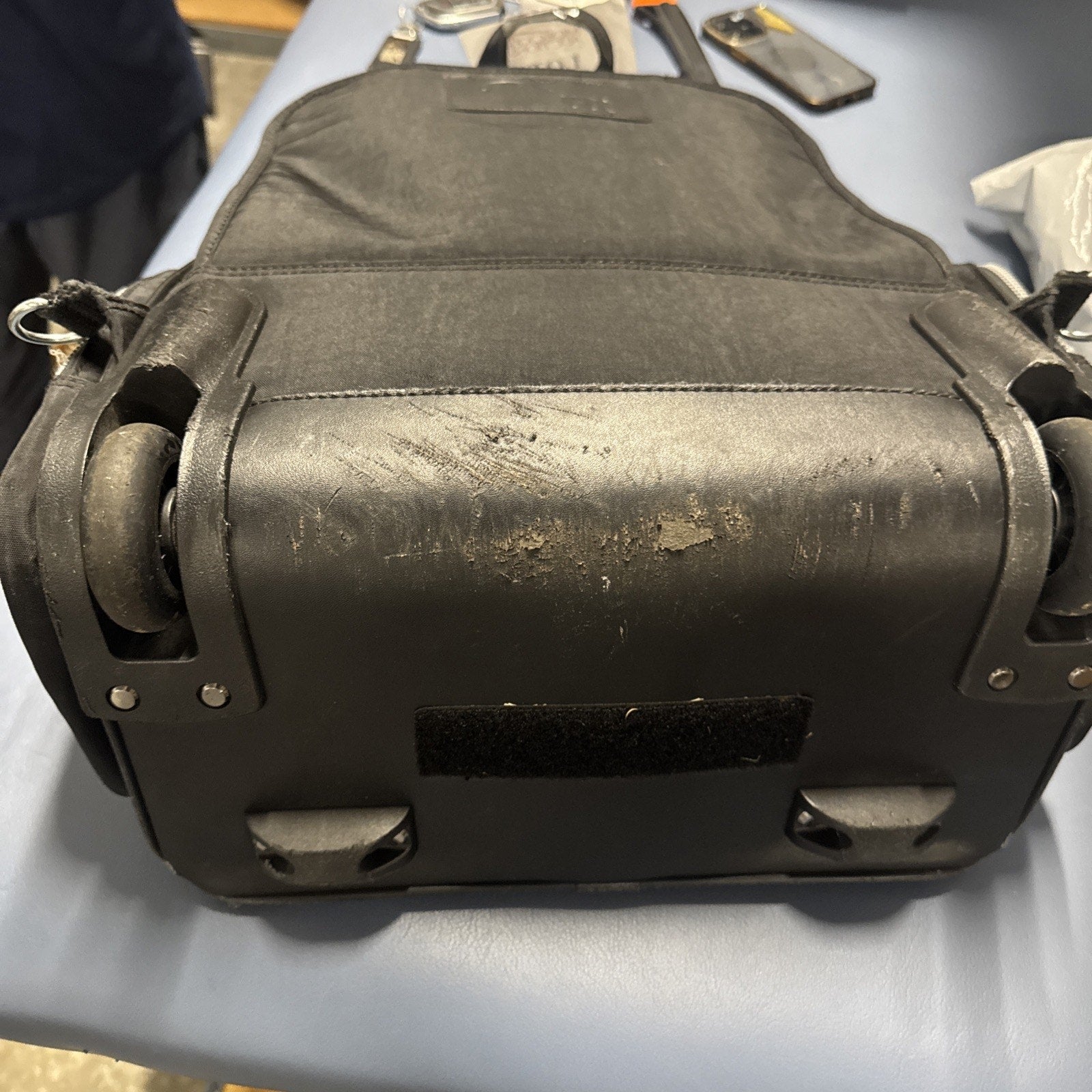Bottom view of pre-owned Kipling Gaze Large Printed Rolling Backpack showing worn wheel base and retractable handle housing