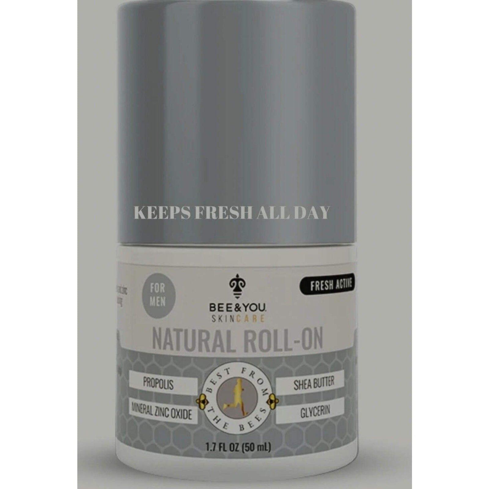 Cylindrical gray and white roll-on deodorant bottle labeled for men, featuring natural ingredients like propolis, shea butter, mineral zinc oxide, and glycerin, with text stating "Keeps fresh all day.