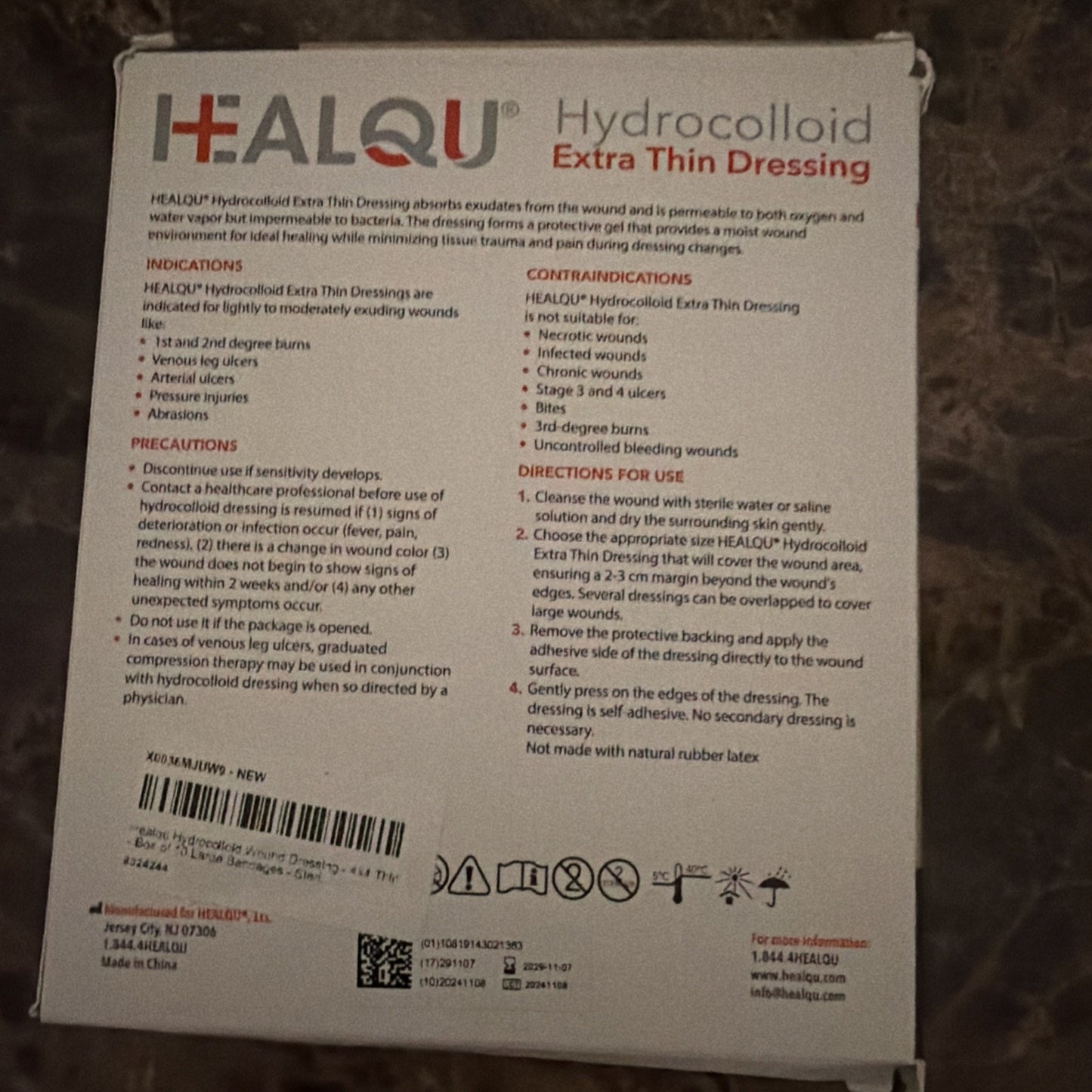 Back of a HEALQU Hydrocolloid Extra Thin Dressing package showing usage instructions, indications, contraindications, precautions, and contact information, with a partially obscured barcode label.
