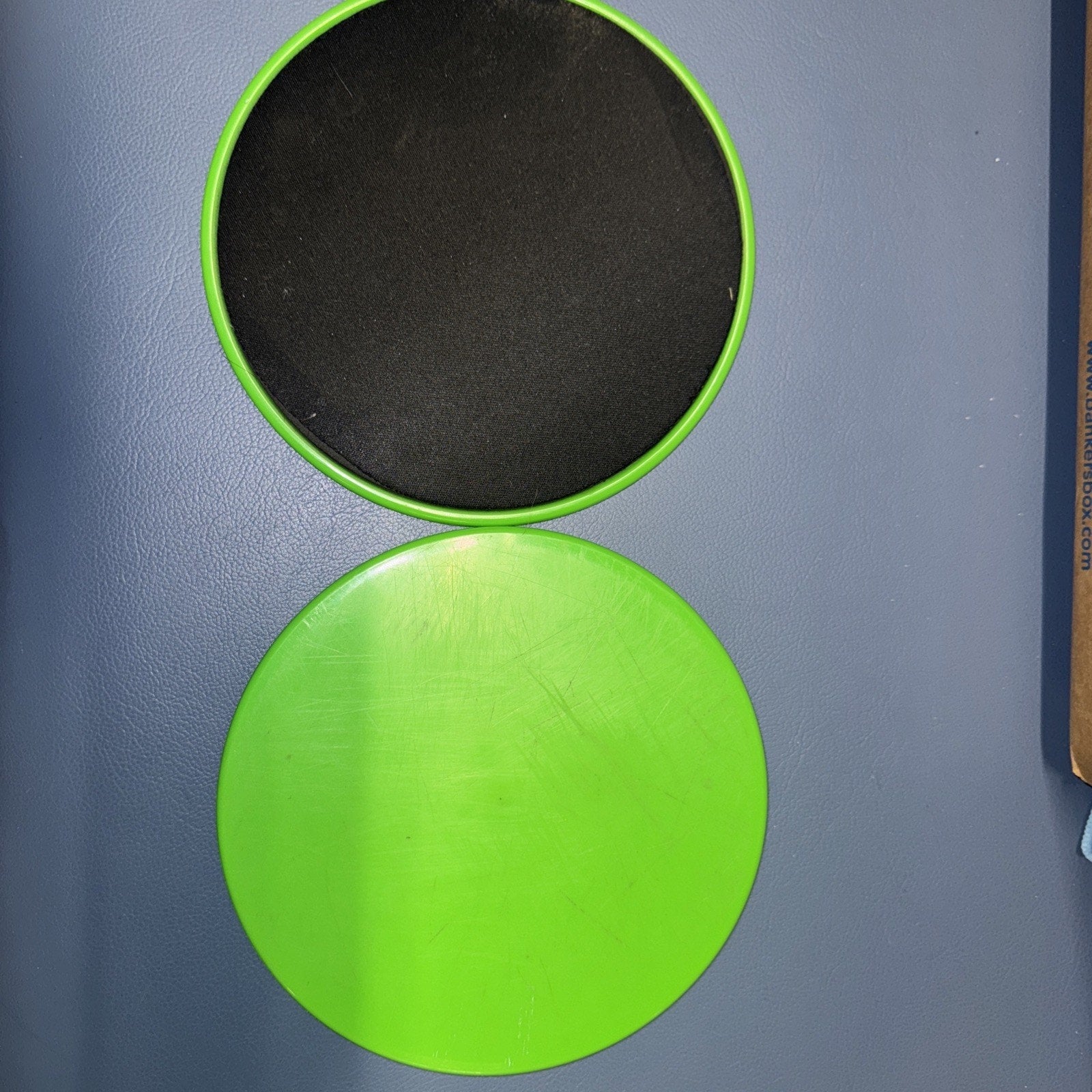 2PCS core exercise sliders with green plastic sides and black smooth gliding surface for abs and full body workouts