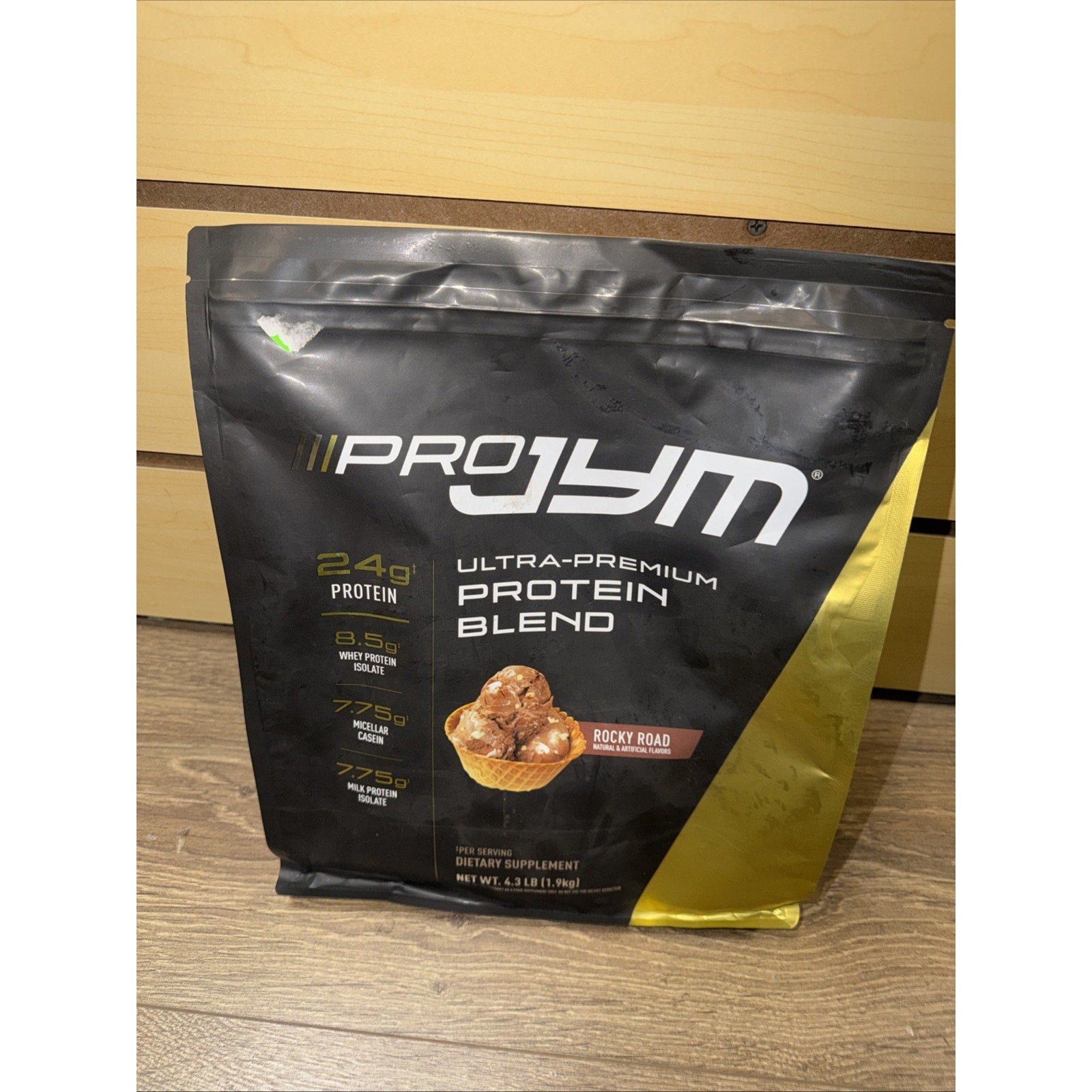 Black and gold resealable pouch of Pro Jym Ultra-Premium Protein Blend in Rocky Road flavor, highlighting 24 grams protein, 5.5 grams BCAAs, and 1.75 grams fat per serving.