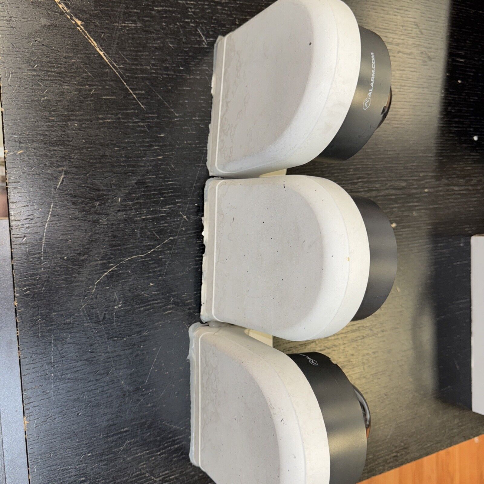 Lot of three Alarm.com surveillance cameras with bases showing infrared lens and mounting hardware details