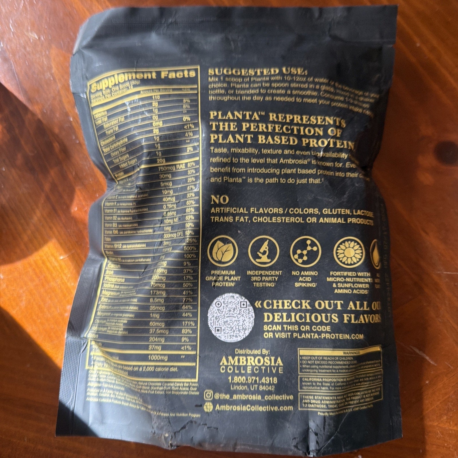 Back of a black resealable bag displaying supplement facts, suggested use instructions, and product benefits including plant-based protein quality, no artificial additives, and third-party testing.