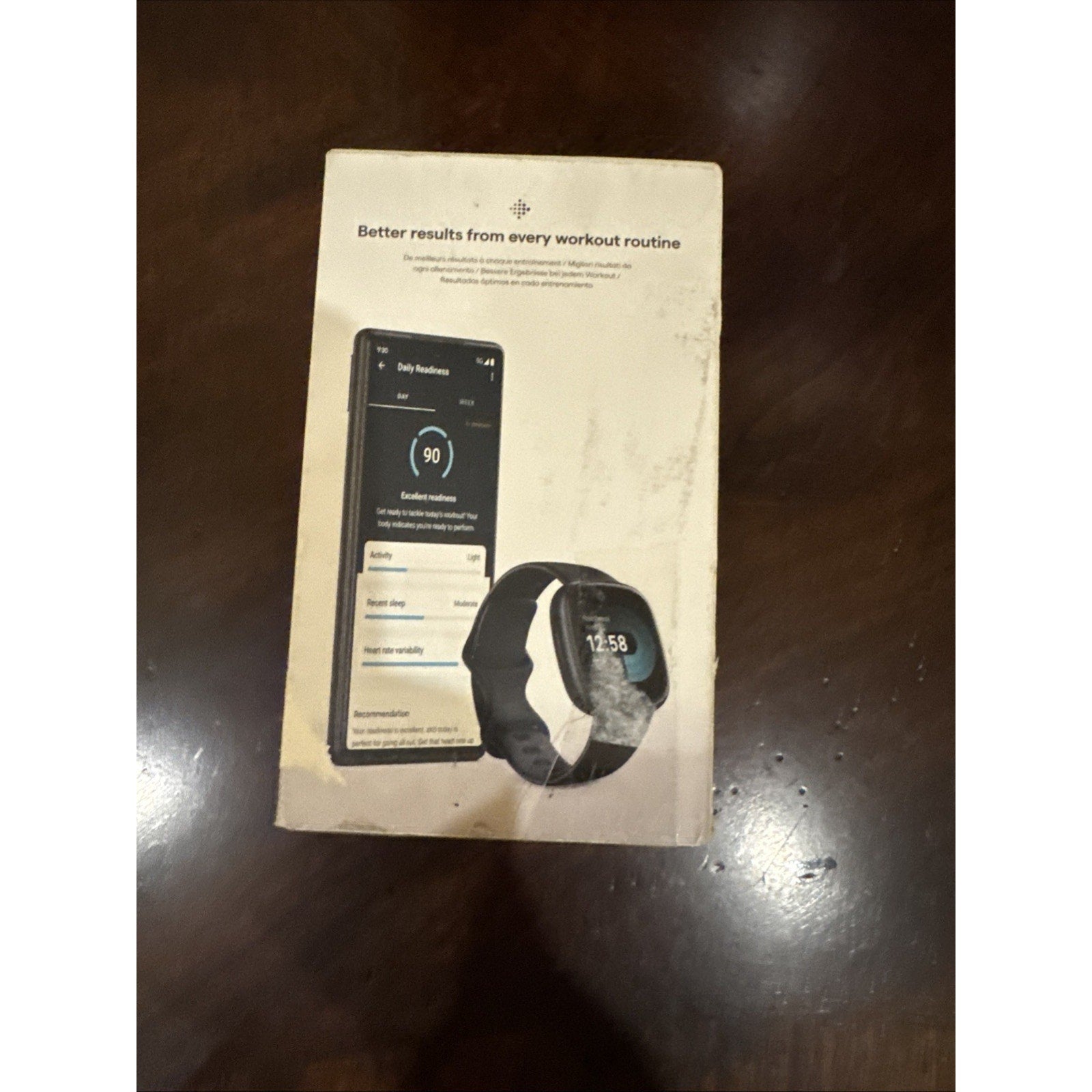 Fitbit Versa 4 Fitness Smartwatch in black with workout tracking and smartphone display on retail box front