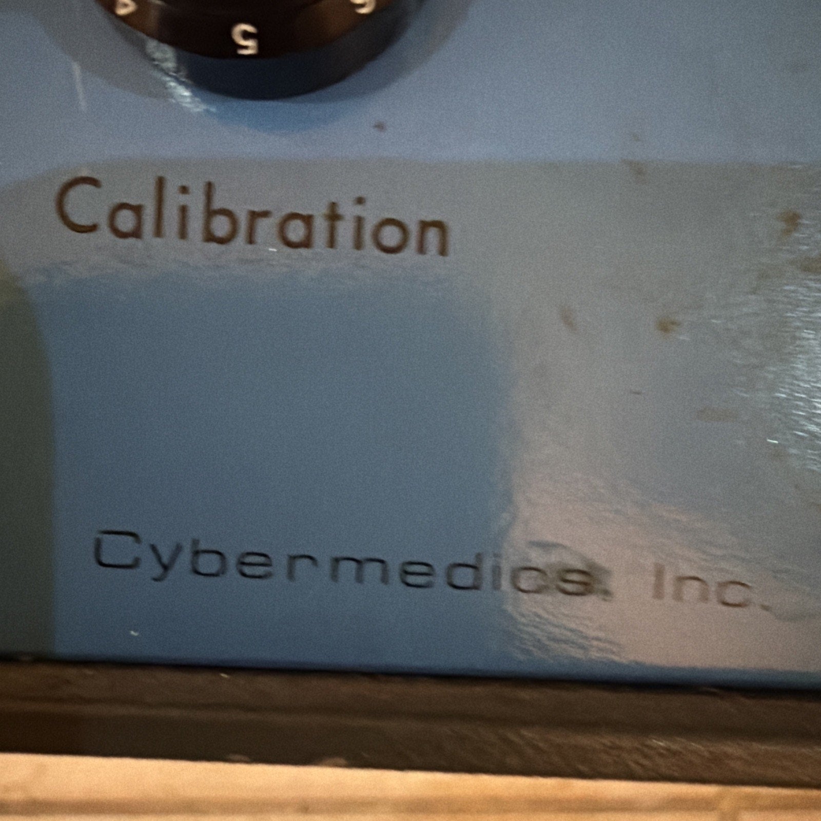 Close-up of Cybermedics Inc. Stenometer cardiology instrument showing calibration dial and company label on blue panel
