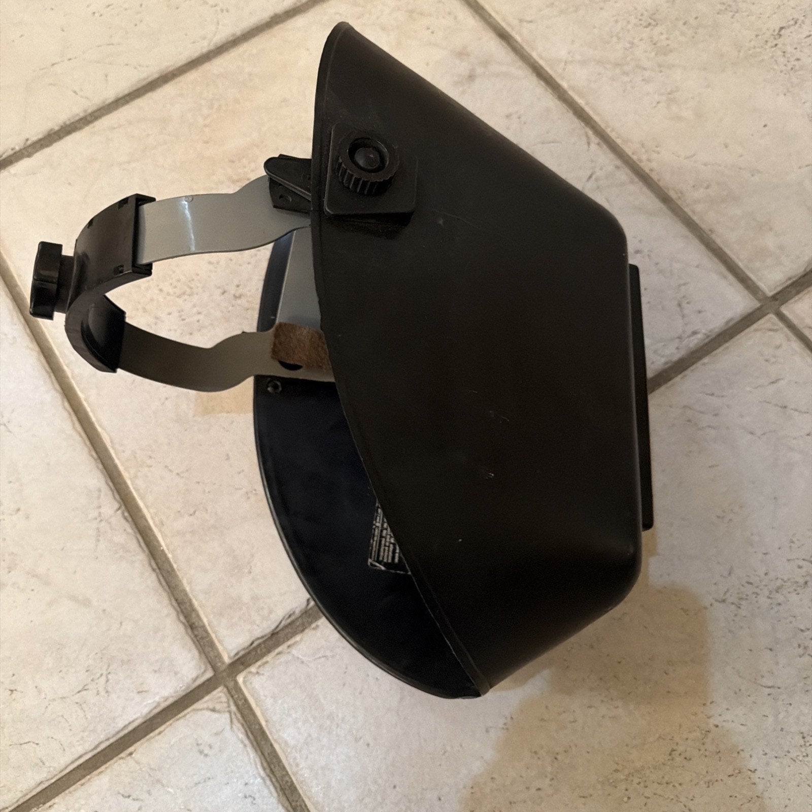 Jackson Safety HSL100 Glory Welding Helmet PRO-V auto-darkening with adjustable headgear shown on tiled floor