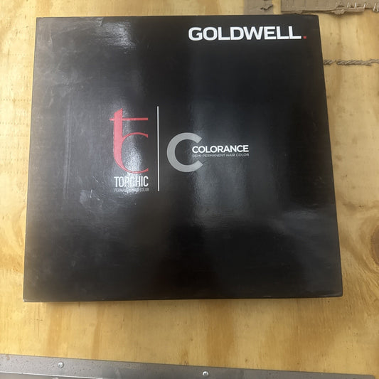 Goldwell Color Catalog black binder with logo and text featuring Topchic and Colorance hair color branding on wood surface