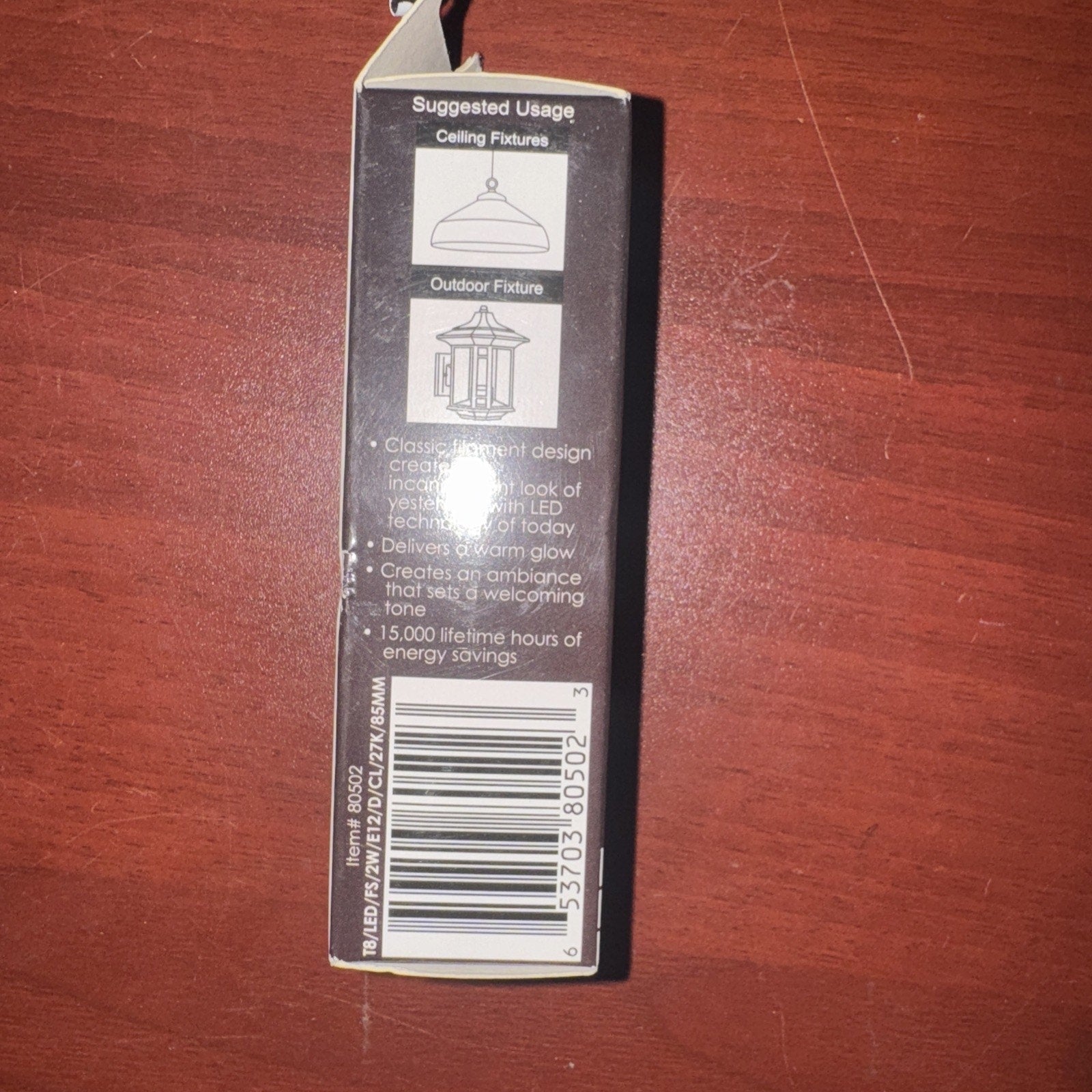 Back of Sunlite 25 W T8 Bulb Lamp box with suggested uses, product details, and barcode on wood surface