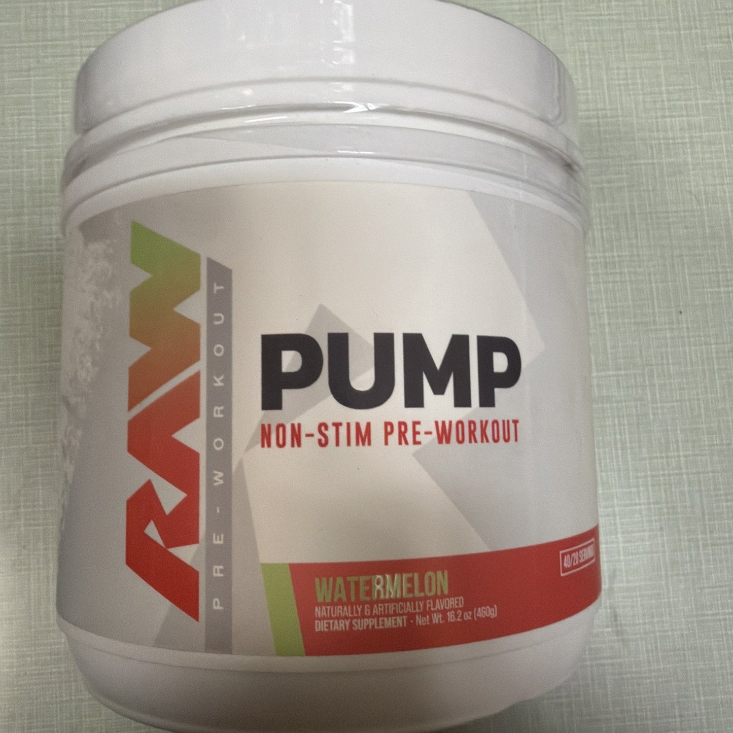 White plastic container of RAW Pump non-stim pre-workout supplement in watermelon flavor, featuring a clean design with green and red accents and labeled dietary supplement.