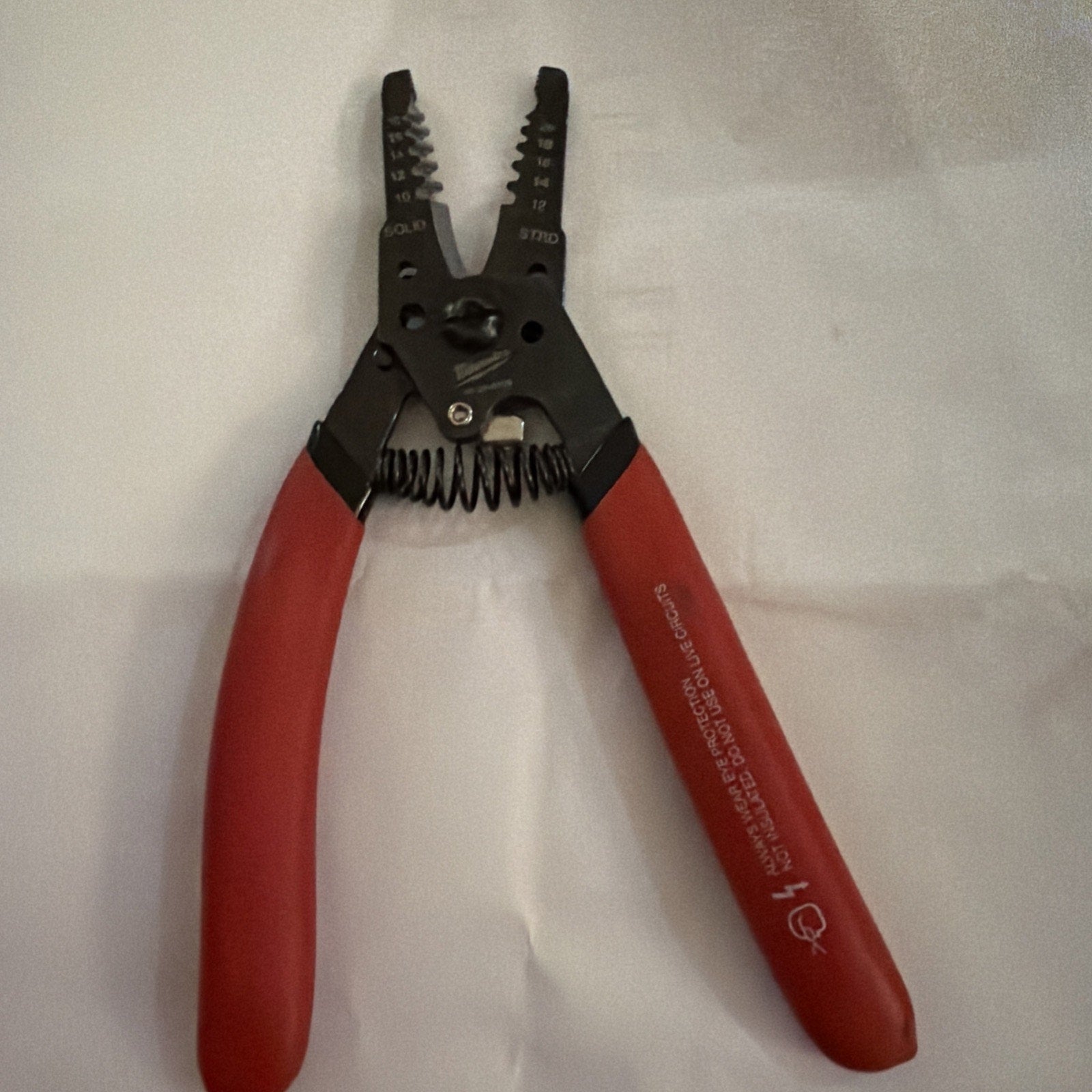 Milwaukee Automatic Wire Stripper with red handles designed for stripping 10 to 20 AWG wire sizes