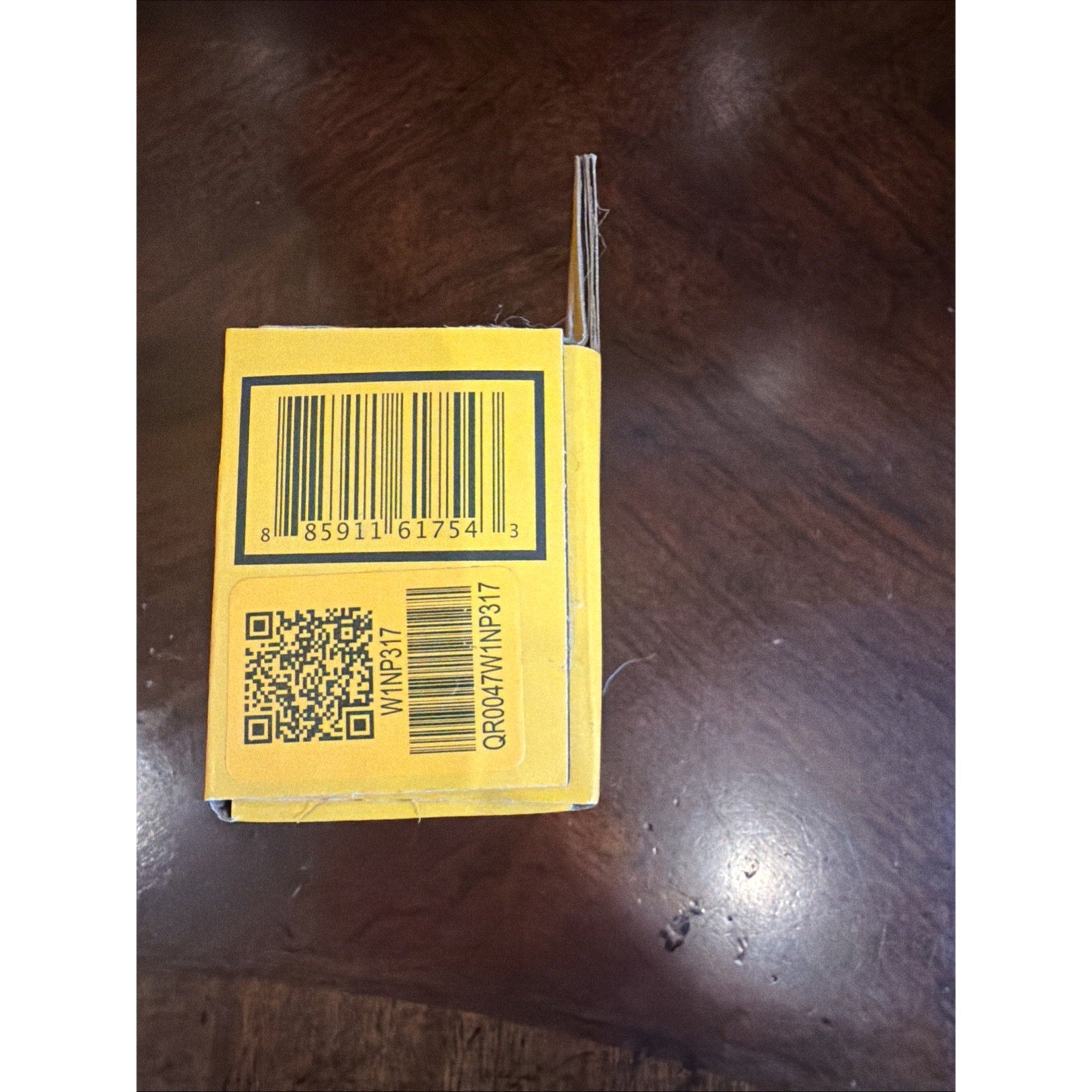 Yellow product box side showing a barcode, QR code, alphanumeric code 