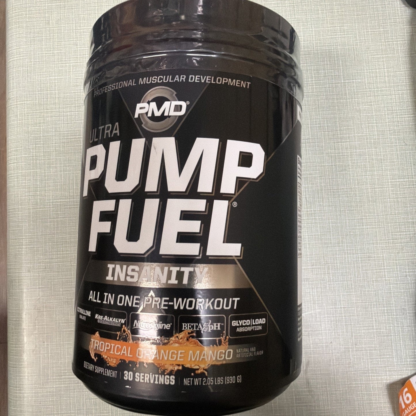 Black container of PMD Ultra Pump Fuel Insanity pre-workout supplement in tropical orange mango flavor, with 30 servings and nutritional highlights displayed on the label.