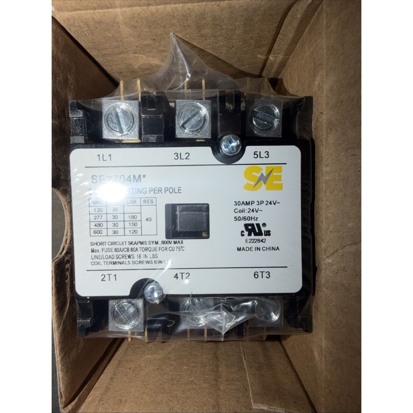 Electrical contactor with black casing, labeled with SAE logo, technical specifications for 30 AMP, 3 poles, 24V coil, and terminal connections, inside a brown cardboard box.