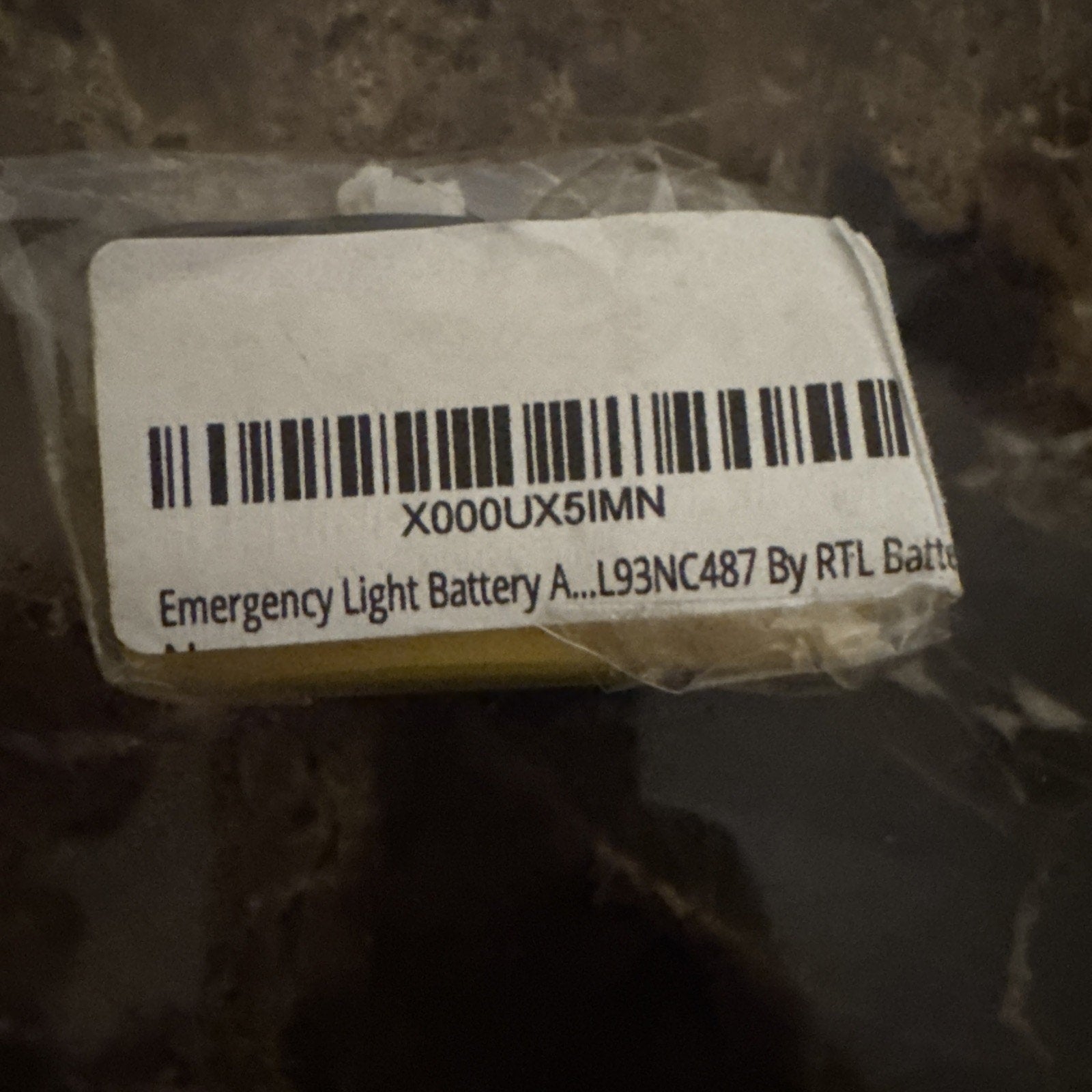 Close-up of 4.8V 700mAH Ni-Cd rechargeable emergency light battery with barcode label and partial text on plastic wrap