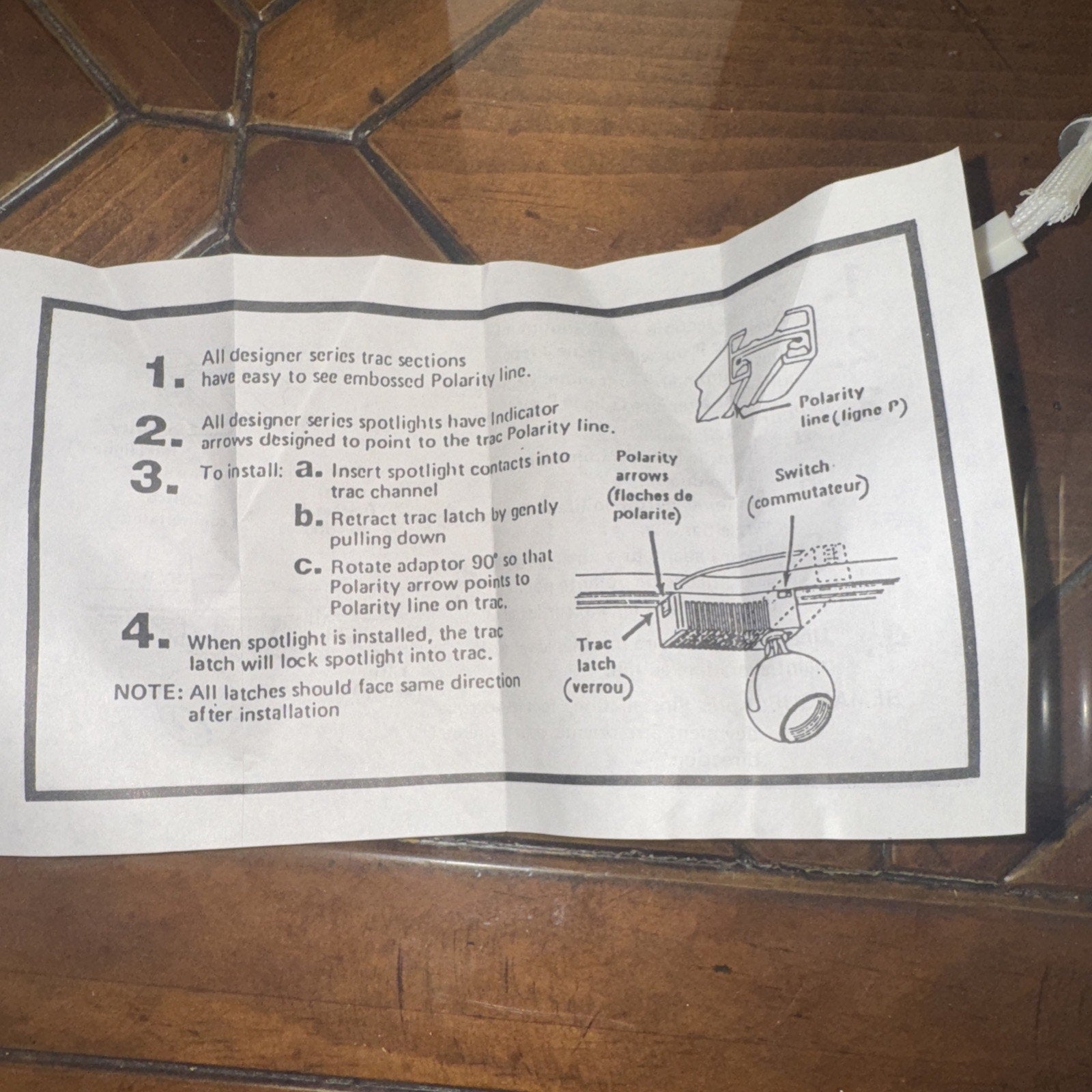 Instruction sheet showing installation steps for designer series track spotlight with polarity and latch details